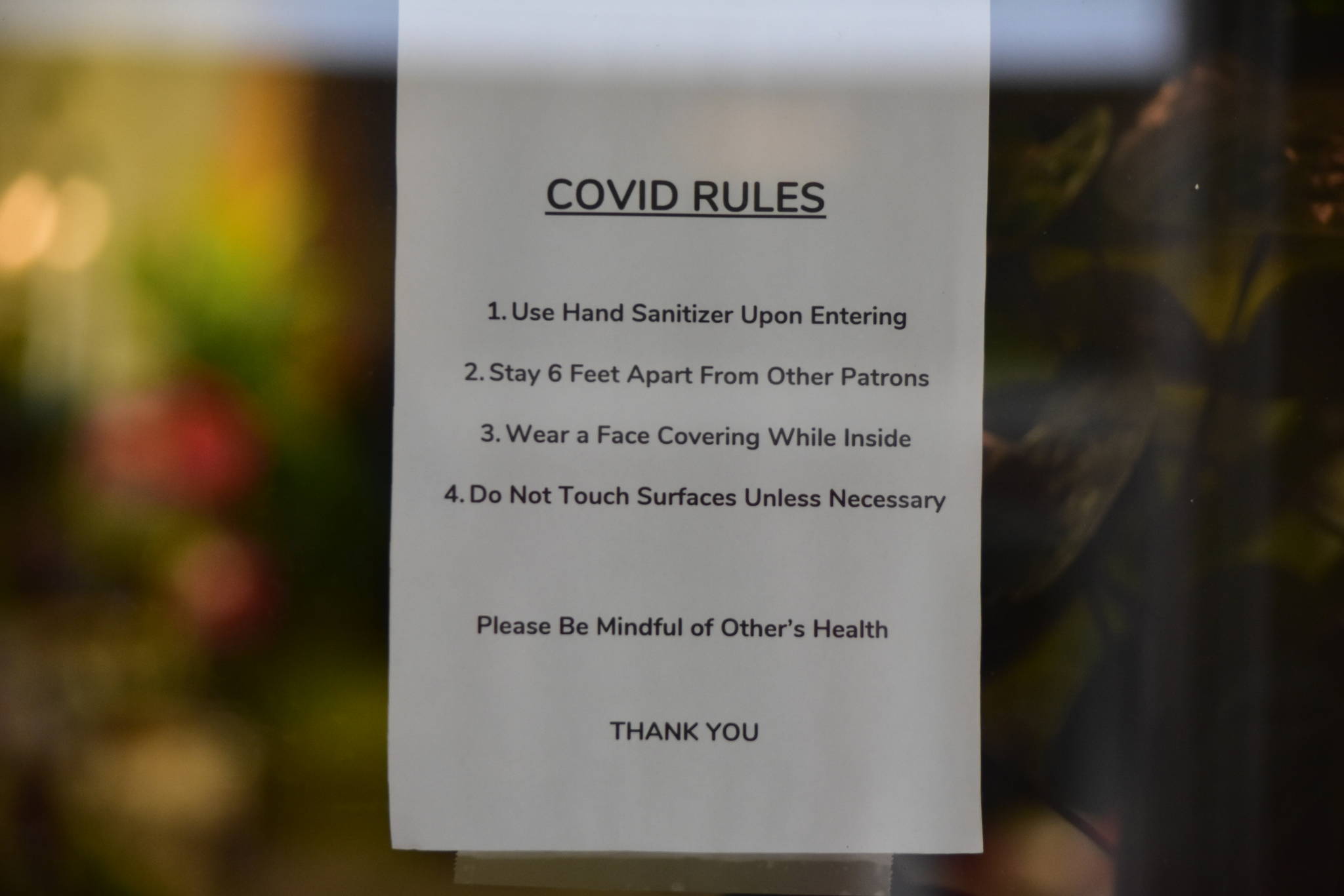 A sign in the window of a shop in downtown Juneau informs customers of rules for entering the business on Dec. 15, 2020. On Monday the City and Borough of Juneau announced it was relaxing some of the restrictions on businesses as the spread of COVID-19 in the community had decreased. (Peter Segall / Juneau Empire)