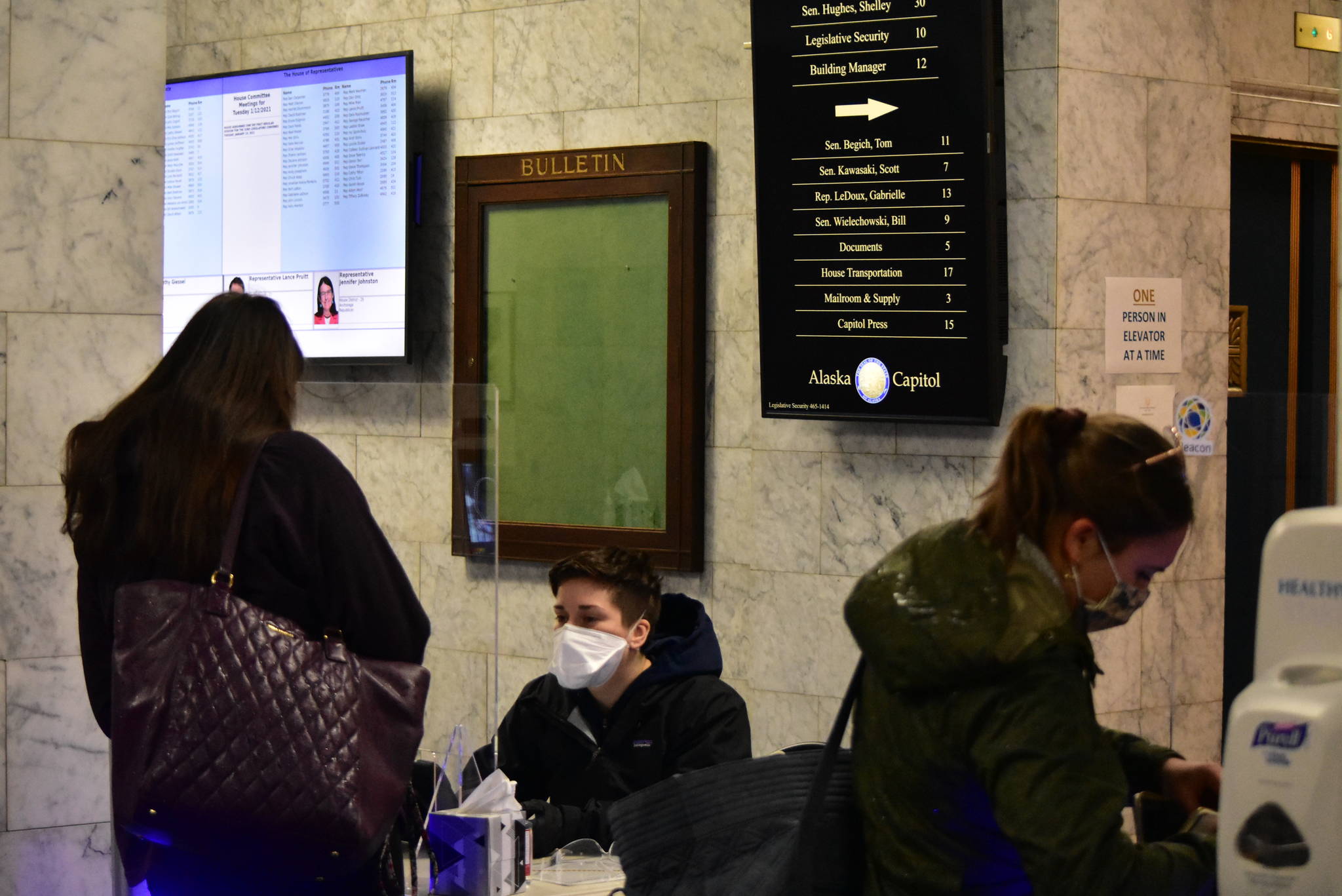 Staff pass through a COVID-19 screening checkpoint set up on the ground floor of the Alaska State Capitol on Tuesday. The new session of the Legislature starts Jan. 19, and some lawmakers and their staff have already arrived in Juneau. (Peter Segall / Juneau Empire)