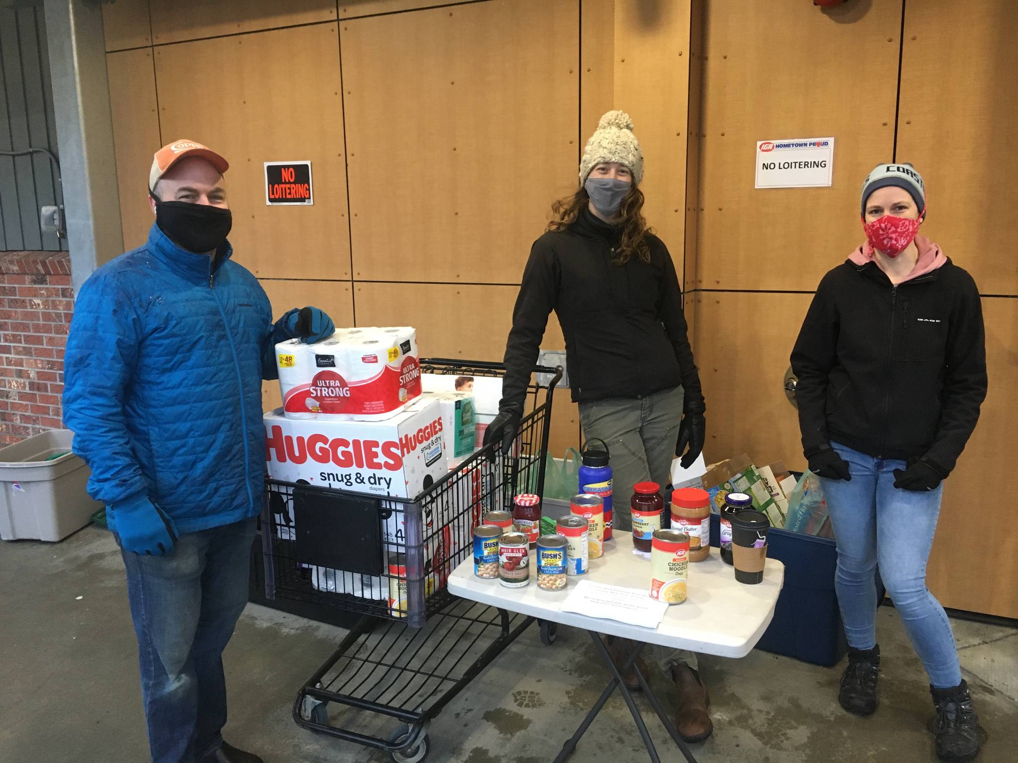 Marc Wheeler, Maddie Kombrink, and Kristi Kraft of Coppa volunteered with the Black Awareness Association of Juneau to help hold a food and childcare needs drive at the Foodland IGA on Dr. Martin Luther King Jr. Day, Jan. 18, 2021. (Michael S. Lockett / Juneau Empire)