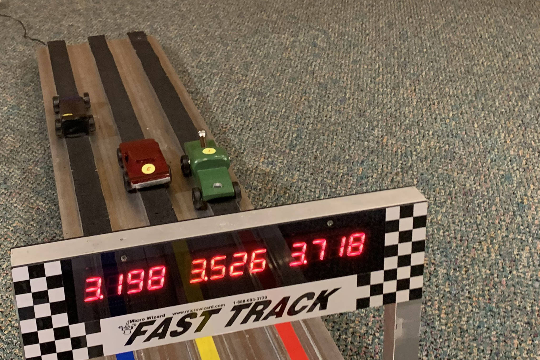 Cars zoom down the track at Saturday's Pinewood Derby. The COVID-19 pandemic forced the race to move a virtual format. (Dana Zigmund/Juneau Empire)