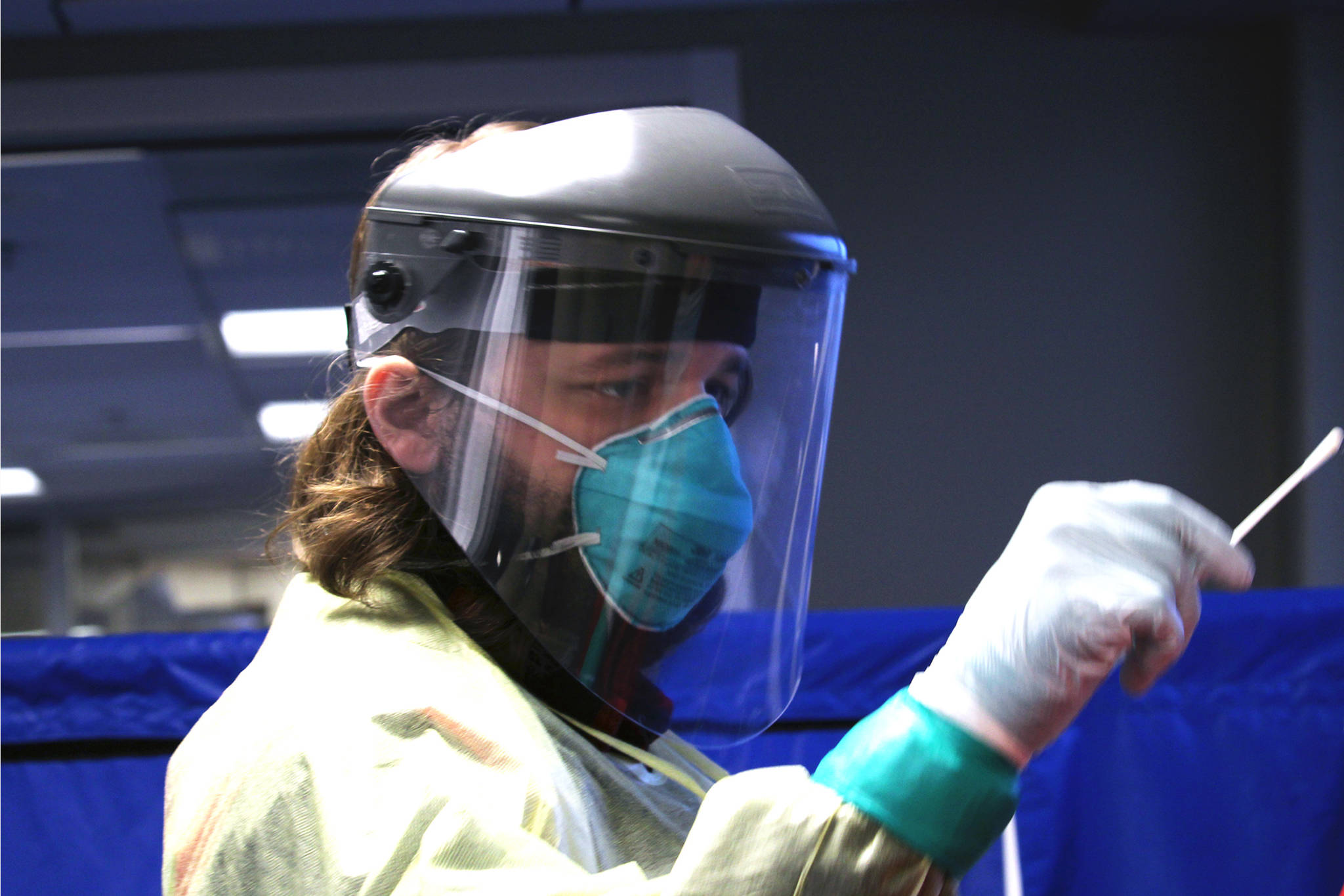 Emergency worker Tyler Morgan administers a COVID-19 test at Juneau International Airport on Sunday, Jan. 10, 2021. (Ben Hohenstatt / Juneau Empire)
