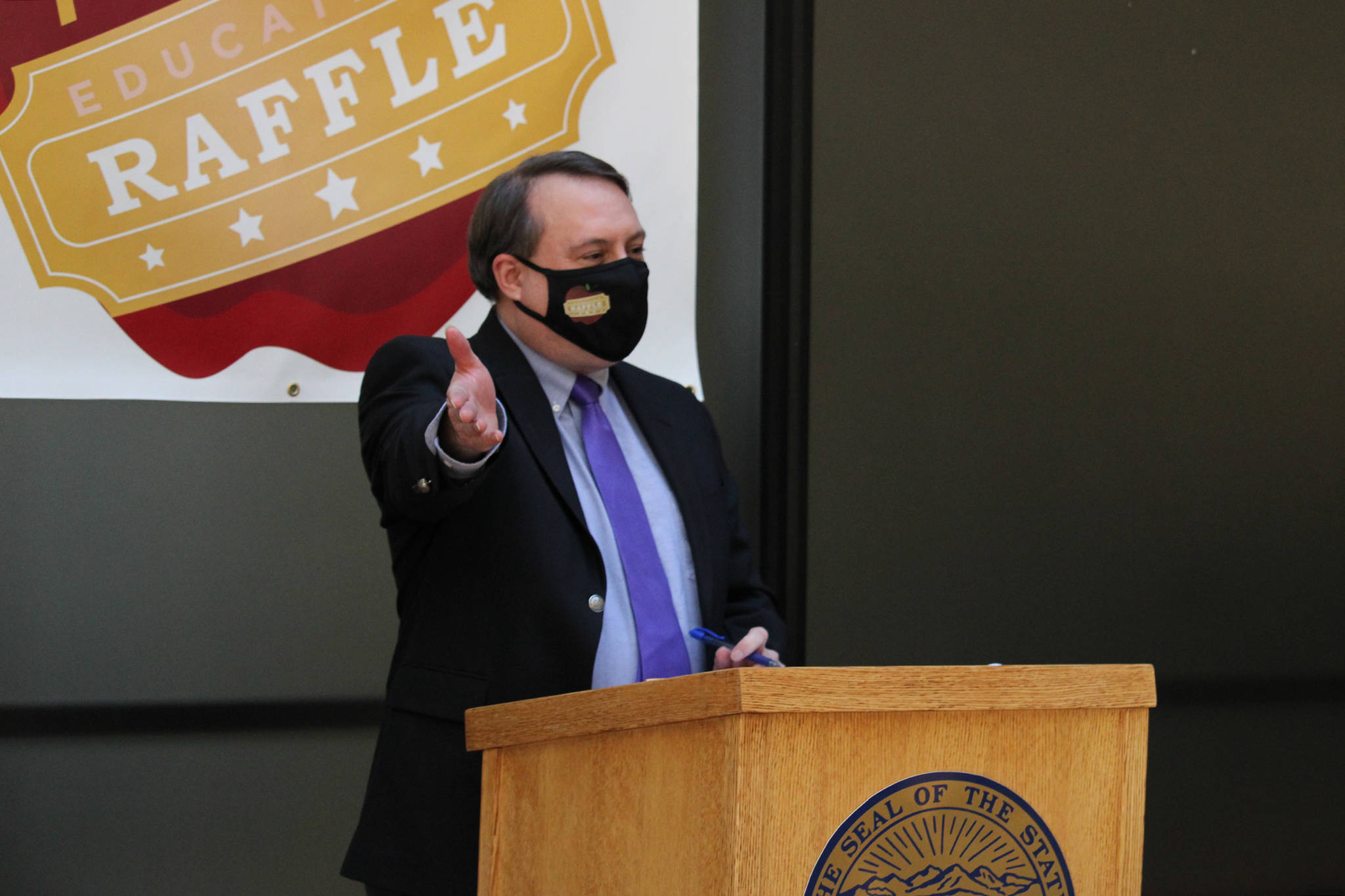 Mike Barnhill, deputy commisioner of the Alaska Department of Revenue, speaks following the drawing of names during the second annual PFD Education Raffle. During the event, state officials and lawmakers wore masks with an education raffle logo. (Ben Hohenstatt / Juneau Empire)