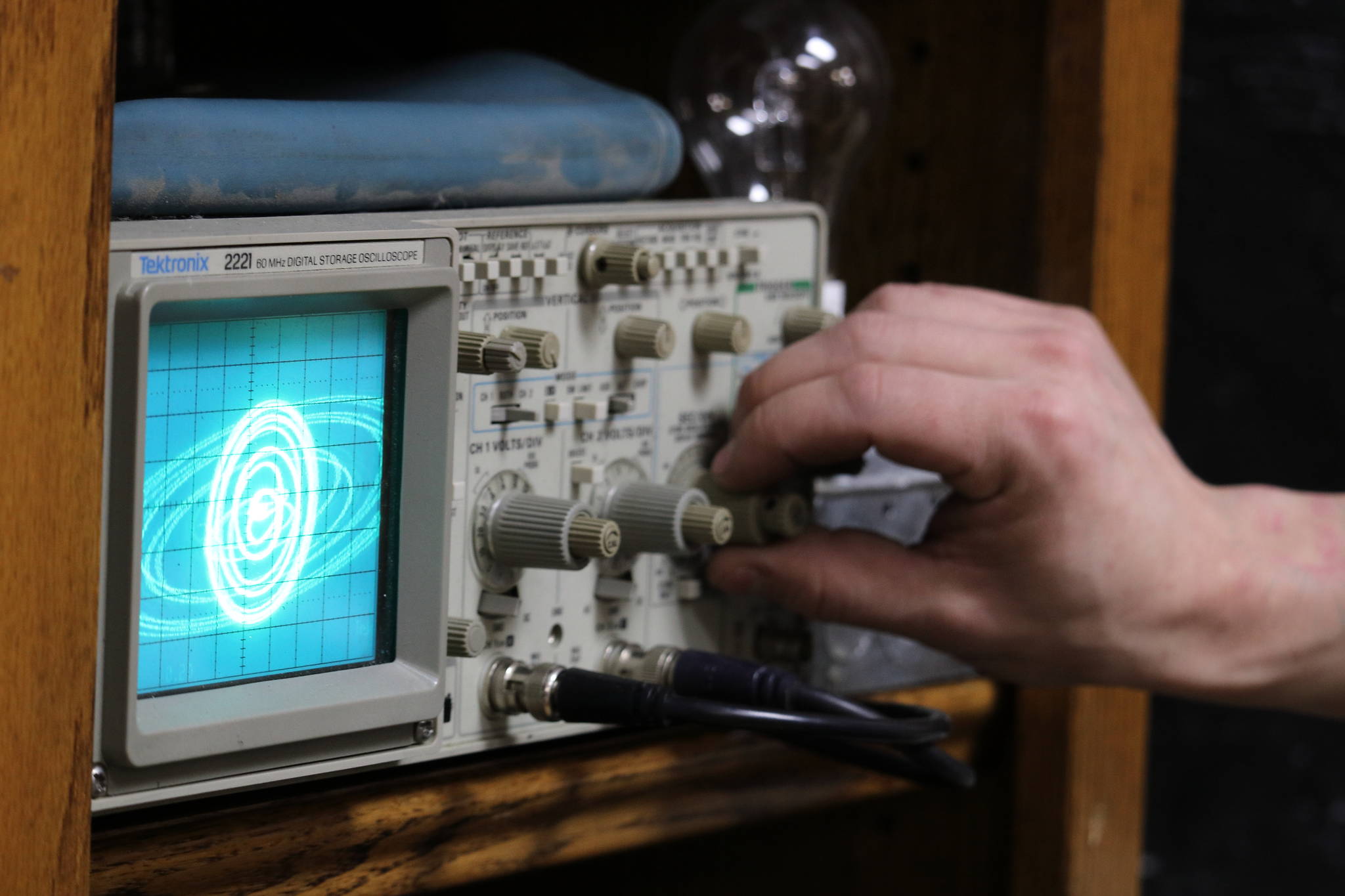 Nano Brooks twists the dial of an oscilloscope — a device that uses electrical signals from sound waves to create images— while the oscilloscope shows an image that looks a lot like an exploding Death Star from “Star Wars.” (Ben Hohenstatt / Juneau Empire)