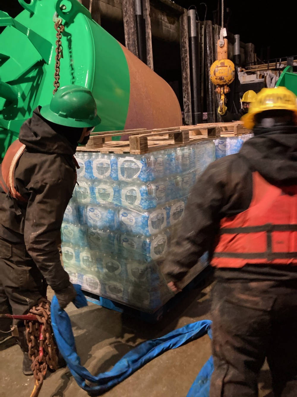 Coast Guard Cutter Hickory crewmembers offload pallets of water destined for the residents in Angoon, Alaska, Feb. 14, 2021. (U.S. Coast Guard photo)
