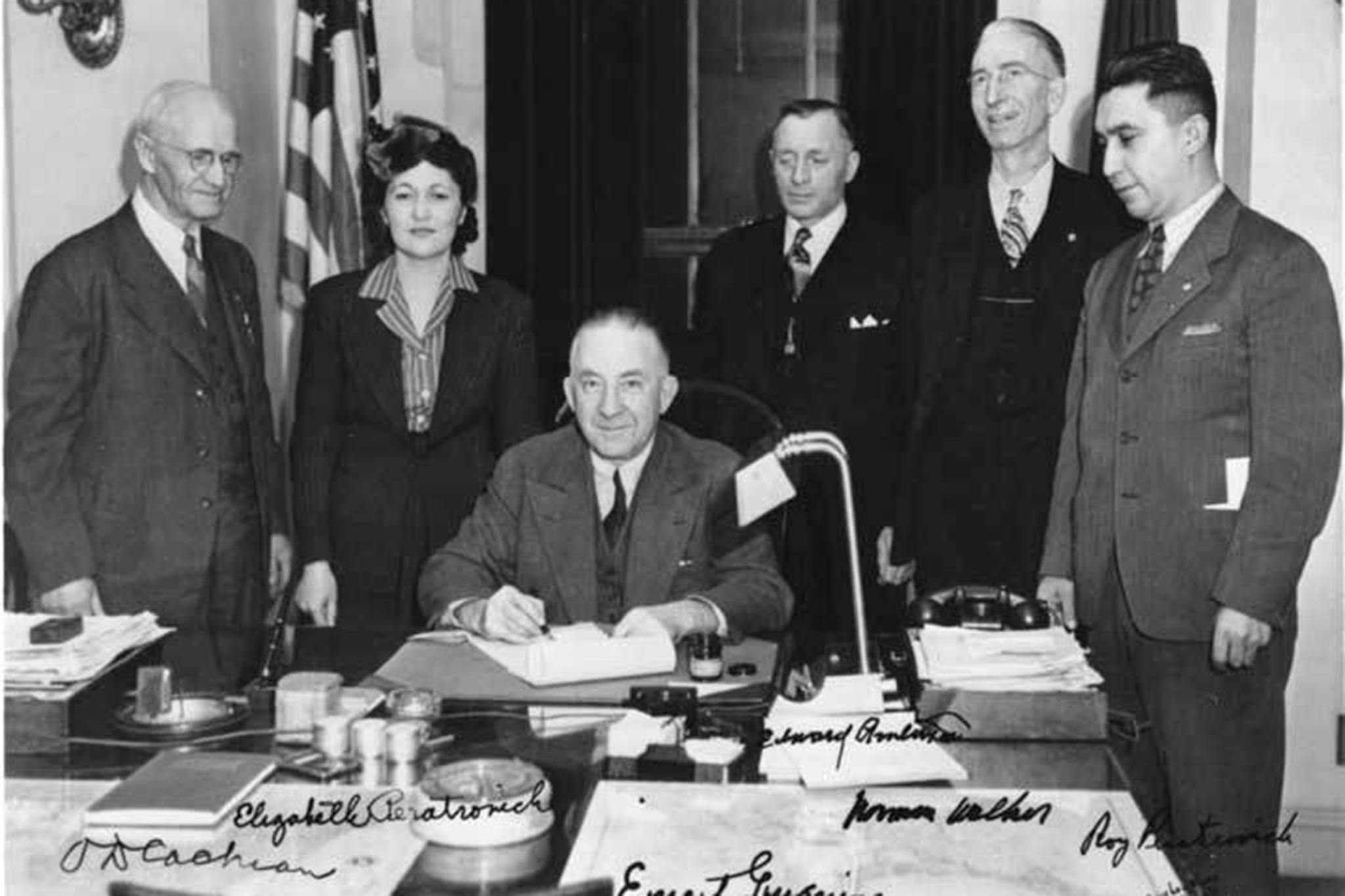 Gov. Ernest Gruening (seated) signs the Alaska Anti-Discrimination Act of 1945. Witnessing are O. D. Cochran, Elizabeth Peratrovich, Edward Anderson, Norman Walker and Roy Peratrovich. (Courtesy Photo / Alaska State Library - Historical Collections)