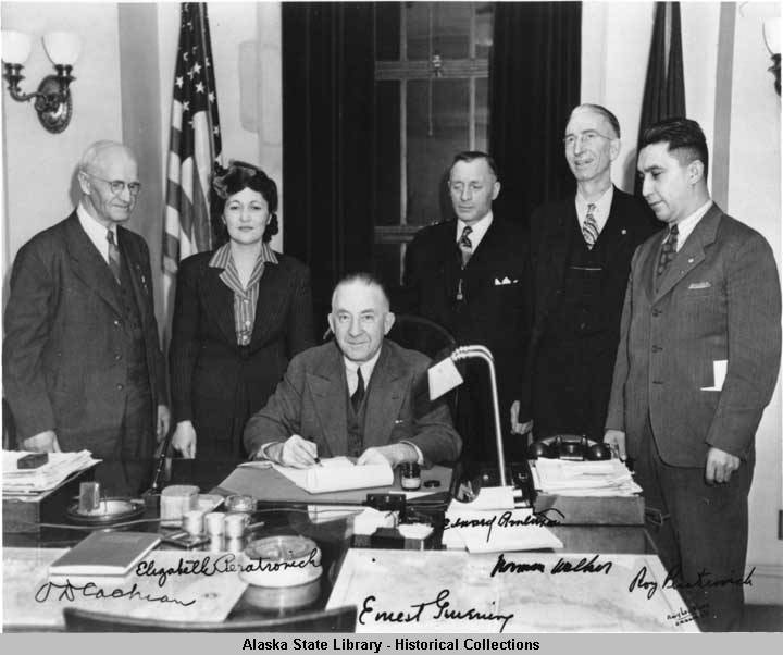 Courtesy Photo / Alaska State Library - Historical Collections 
Gov. Ernest Gruening (seated) signs the anti-discrimination act of 1945. Witnessing are O. D. Cochran, Elizabeth Peratrovich, Edward Anderson, Norman Walker and Roy Peratrovich.