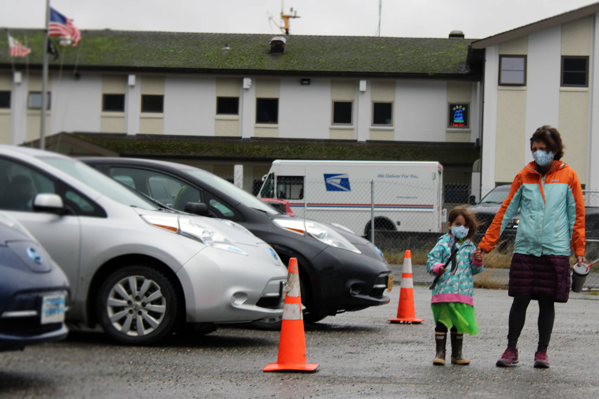 Nathea Burnet holds both a plastic ax and her grandmother, Patricia Forrest's, hand while looking at electric vehicles during Juneau Electric Vehicle Association's road rally Saturday, Sept. 26, 2020. On a per capita basis, there is one electric vehicle per 76 residents in Juneau. There were 418 EVs registered in Juneau as of November 2020. (Ben Hohenstatt / Juneau Empire File)