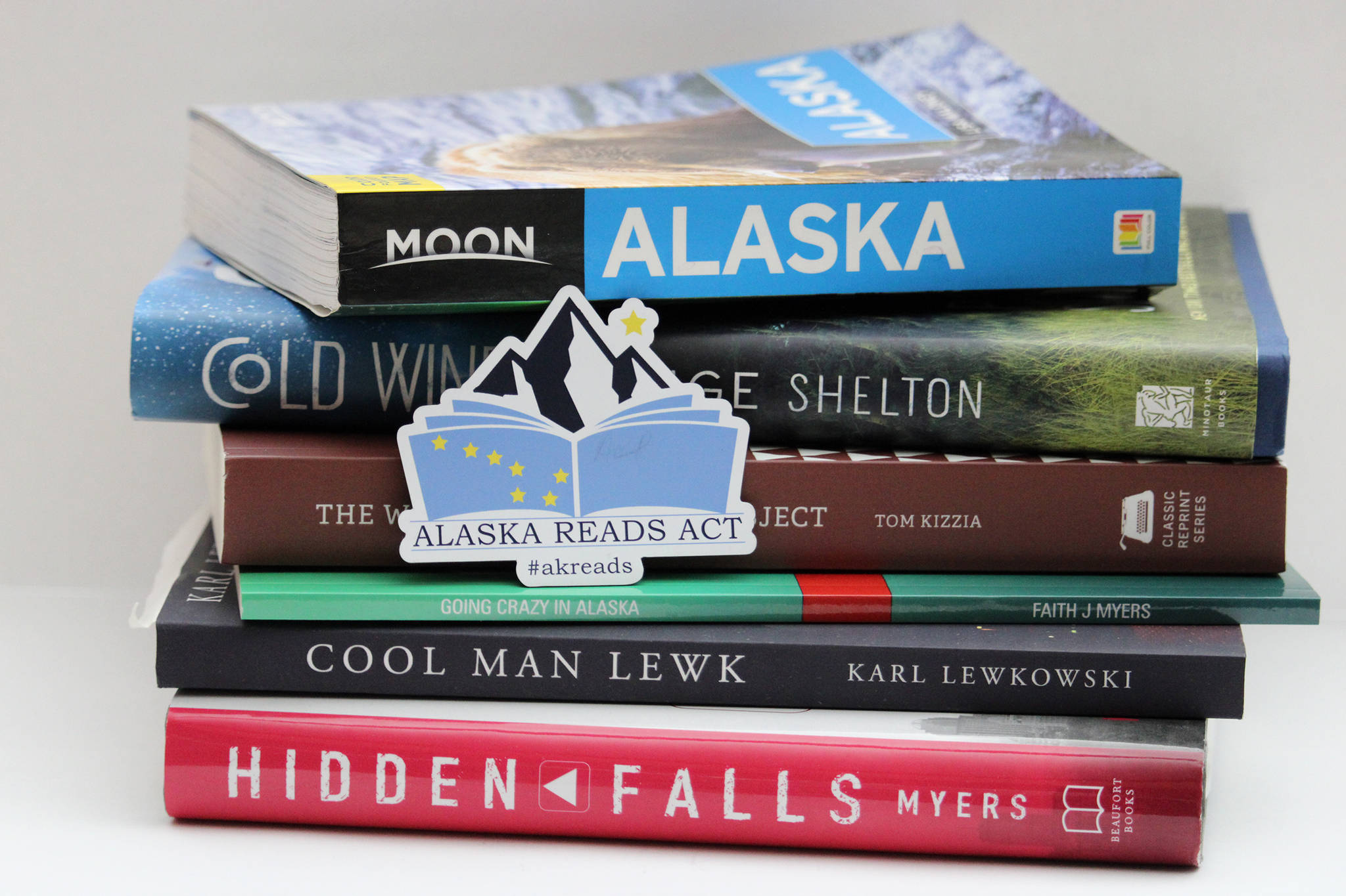 A magnet promoting the Alaska Reads Act released by the state last year sits atop a stack of Alaskan-authored and Alaska-centric books. A shortened session last year meant the bill, announced by Senate Minority Leader Tom Begich, D-Anchorage, and Gov. Mike Dunleavy, didn't make it through the last Legislature. But there's a new bill, nearly the same as the old bill, working its way through the Senate. (Ben Hohenstatt / Juneau Empire file)