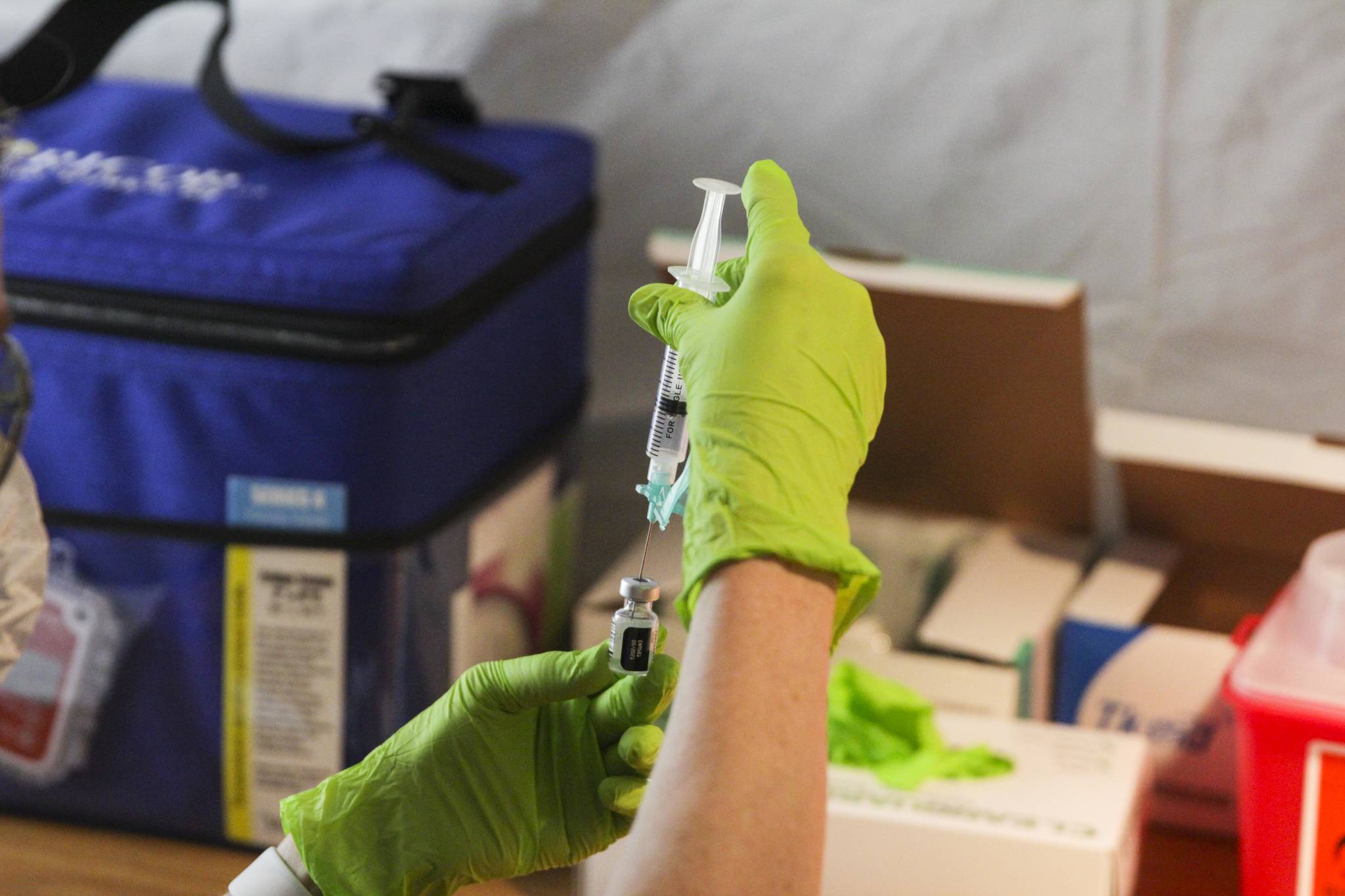 Michael Lockett / Juneau Empire File
A health worker prepares a dosage of COVID-19 vaccine at a clinic at Centennial Hall on Feb. 11. A surge in vaccine availability means more people can get the vaccine, but so far few people are being required to get it.