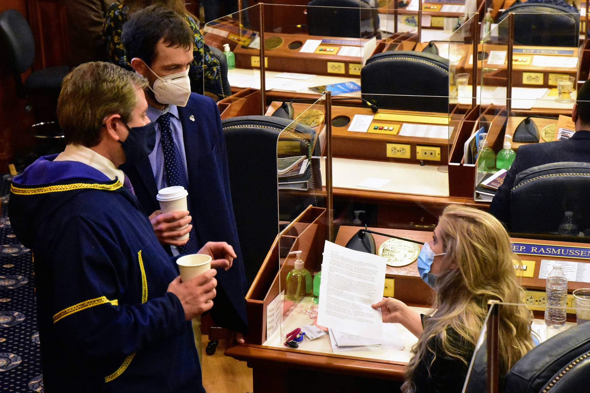 From left to right: Alaska state Reps. Chris Tuck, D-Anchorage, Zack Fields, D-Anchorage, and Sara Rasmussen, R-Anchorage, speak on the Alaska House floor on Friday, March 5, 2021. The House passed a Sense of the House on Friday, condemning as inappropriate and objectifying comments Fields had made toward Rasmussen last month. (Peter Segall / Juneau Empire)