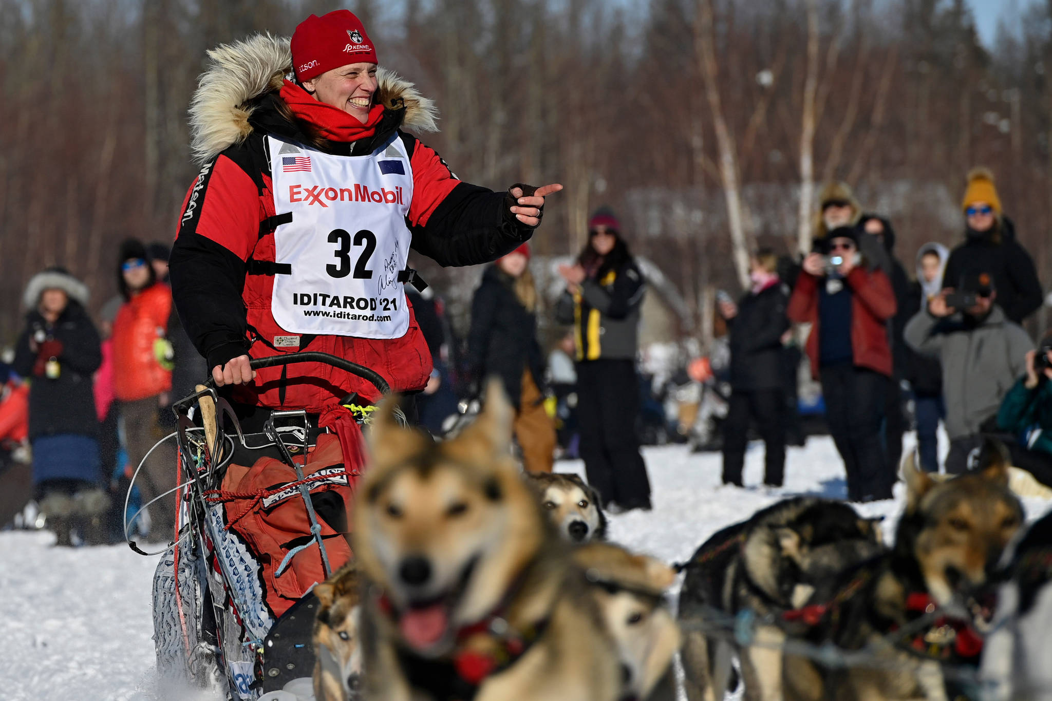 Aliy Zirkle, of Two Rivers, greets fans as she passes by at the Iditarod Sled Dog Race start at Deshka Landing in Willow, Alaska, Sunday, March 7, 2021. (Marc Lester / Anchorage Daily News)