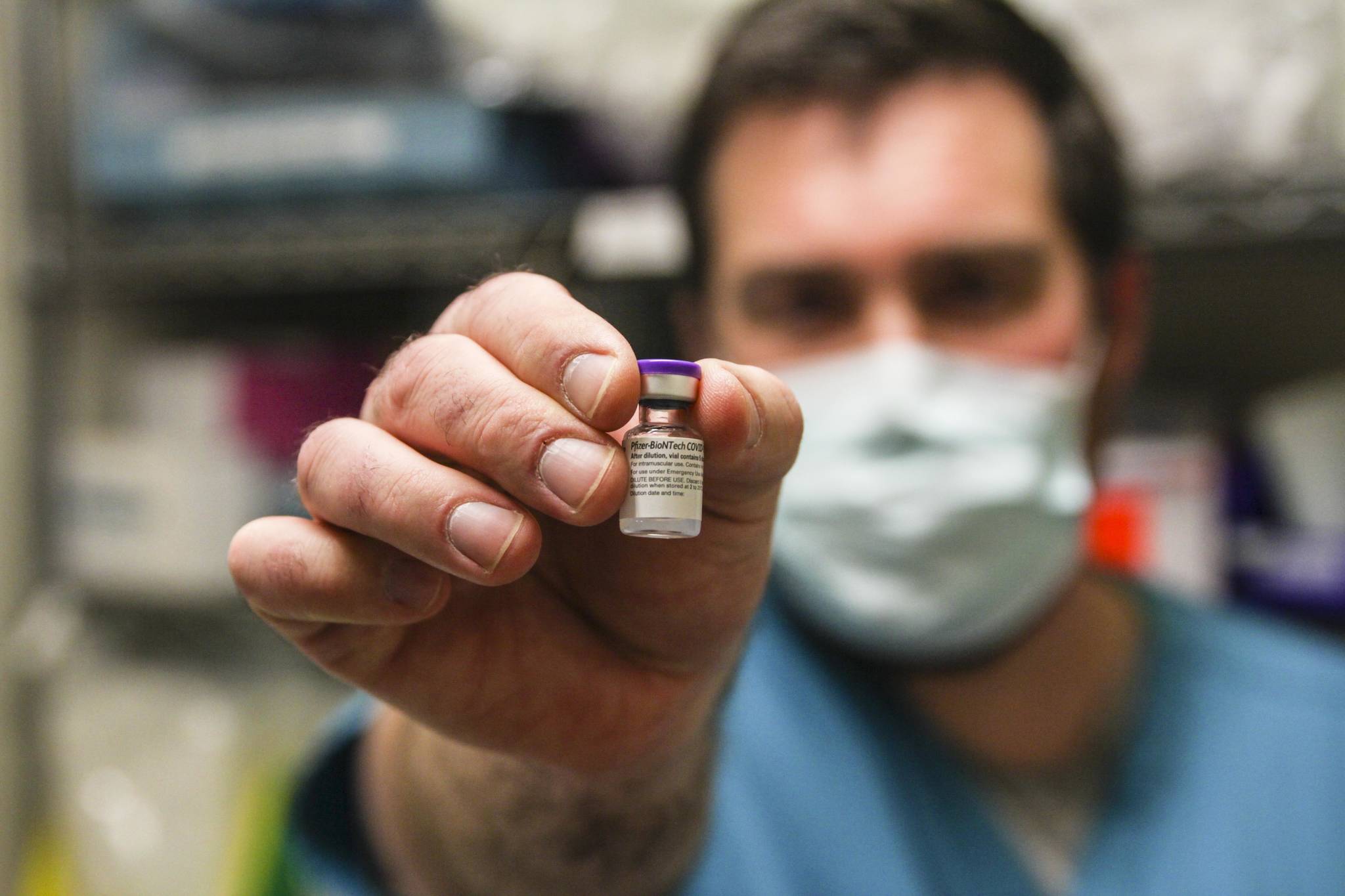Bartlett Regional Hospital pharmacist Chris Sperry holds a vial of COVID-19 vaccine on Dec. 15, 2020. (Michael S. Lockett / Juneau Empire File)