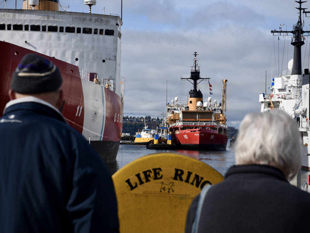 Family members watch as U.S. Coast Guard Cutter Polar Star (center) arrives back to its homeport in Seattle on Feb. 20, 2021. (Petty Officer 2nd Class Steve Strohmaier / U.S. Coast Guard)