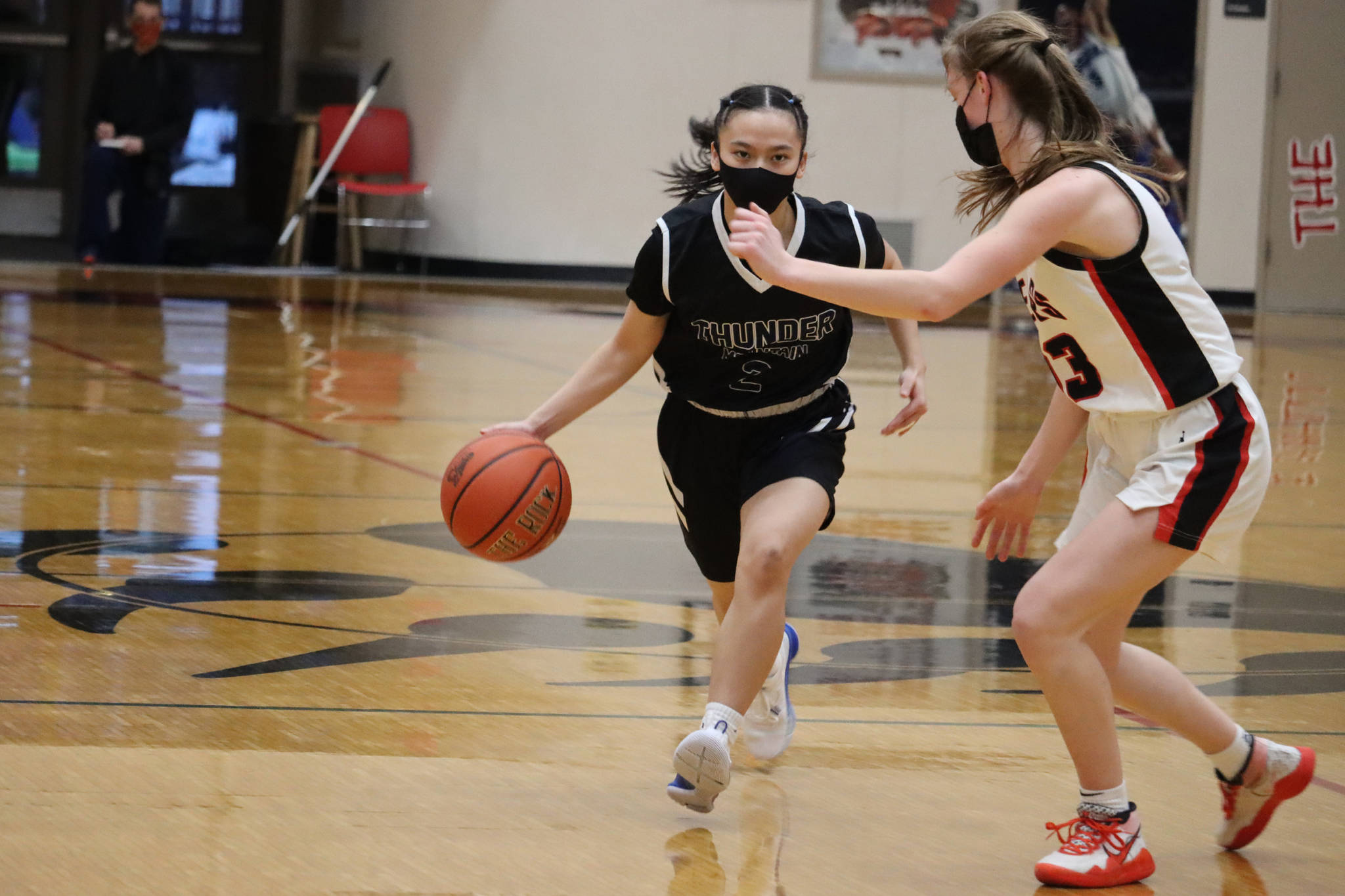Thunder Mountain High School’s Mary Khaye Garcia (2) dribbles toward Juneau-Douglas High School: Yadaa.at Kalé’s Skylar Tuckwood (13) during a 46-41 TMHS victory. It took four quarters and two overtime periods to determine which team would go on to face Ketchikan High School in Ketchikan. (Ben Hohenstatt / Juneau Empire)