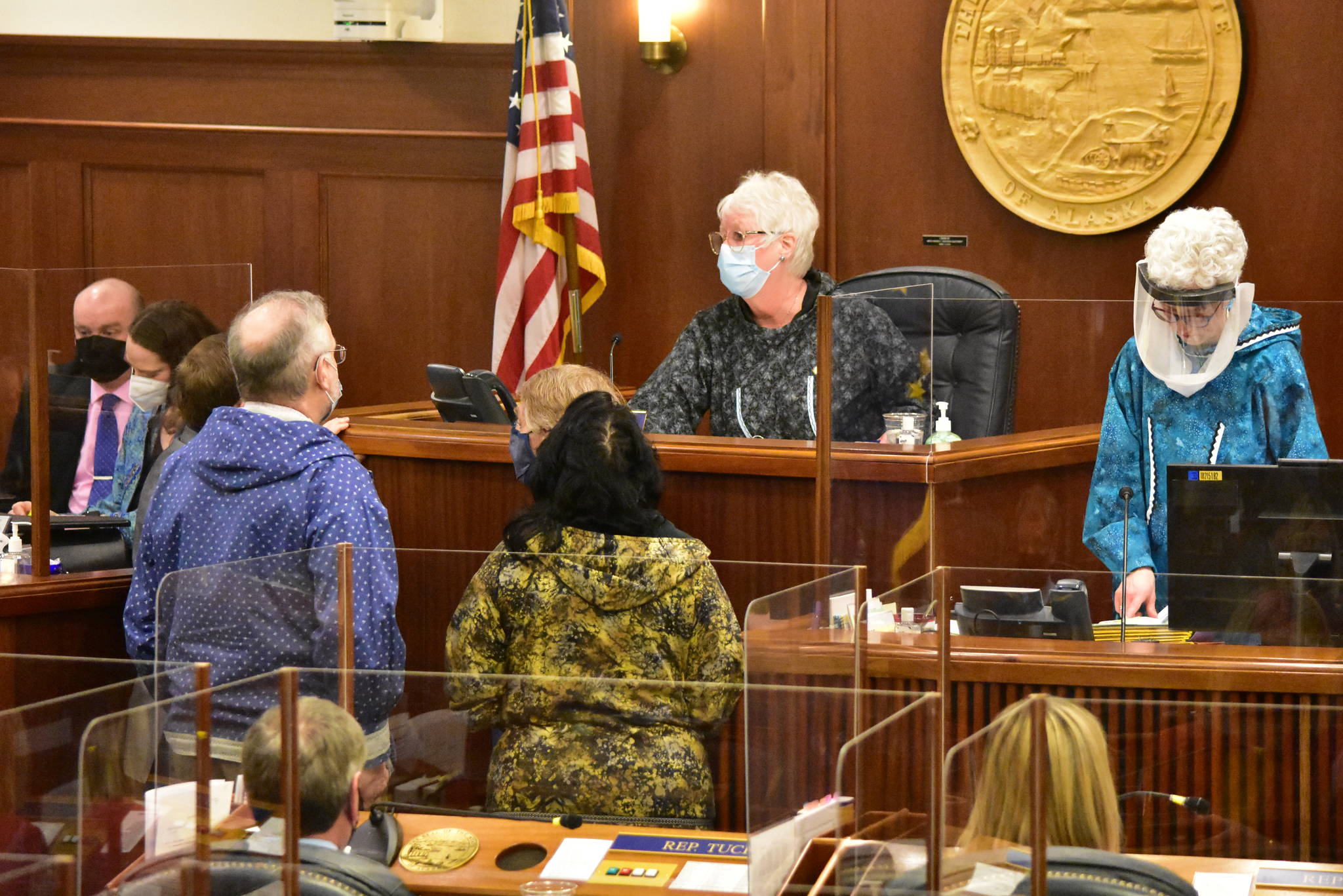 Speaker Louise Stutes, R-Kodiak, speaks to Rep. Chris Kurka, R-Wasilla, who’s behind Rep. Bryce Edgmon, I-Dillingham, at left, regarding the wording on his face mask on Friday, March 19, 2021. (Peter Segall / Juneau Empire)