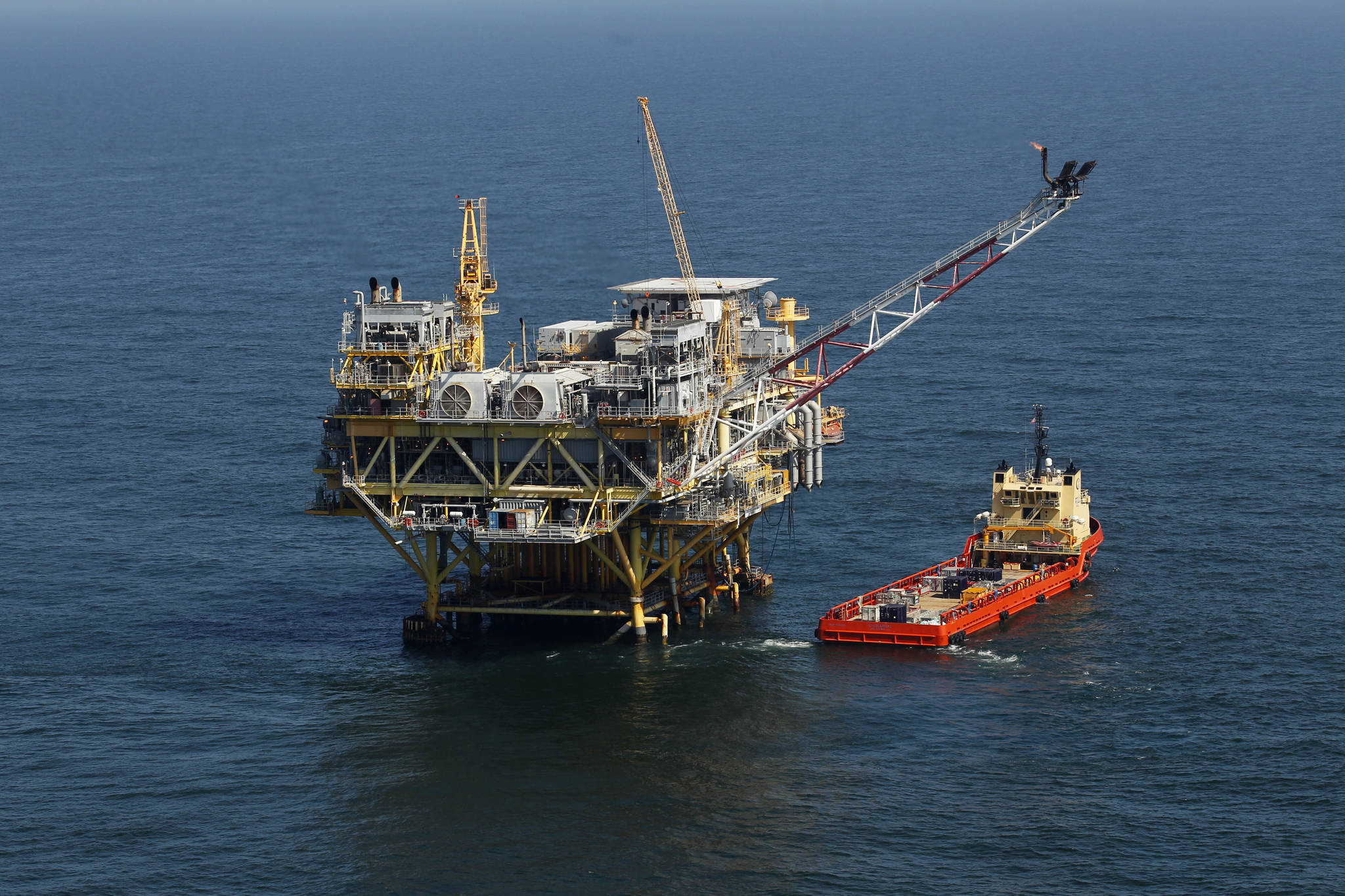 This photo shows a rig and supply vessel in the Gulf of Mexico, off the cost of Louisiana. Thirteen states sued the Biden administration Wednesday, March 24, 2021 to end a suspension of new oil and gas leases on federal land and water and to reschedule canceled sales of offshore leases in the Gulf of Mexico, Alaska waters and western states. The Republican-leaning states, led by Louisiana Attorney General Jeff Landry, seek a court order ending the moratorium imposed after Democratic President Joe Biden signed executive orders on climate change on Jan. 27. (AP Photo / Gerald Herbert)