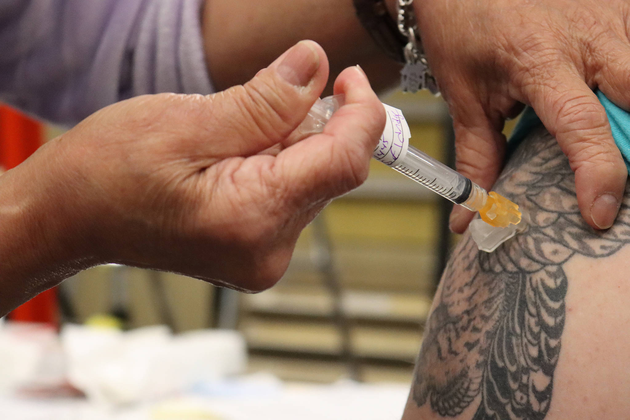 Department of Veterans Affairs nurse Dale Cotton administers a dose of Johnson & Johnson COVID-19 vaccine. (Ben Hohenstatt / Juneau Empire)