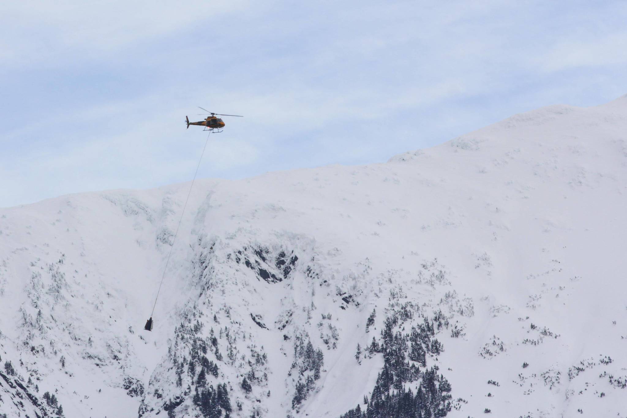 The Alaska Department of Transportation and Public Facilities, contracting with Coastal Helicopters, works to reduce avalanche risk on Thane Road by setting off avalanches in a controlled fashion on Feb. 5, 2021.(Michael S. Lockett / Juneau Empire File)