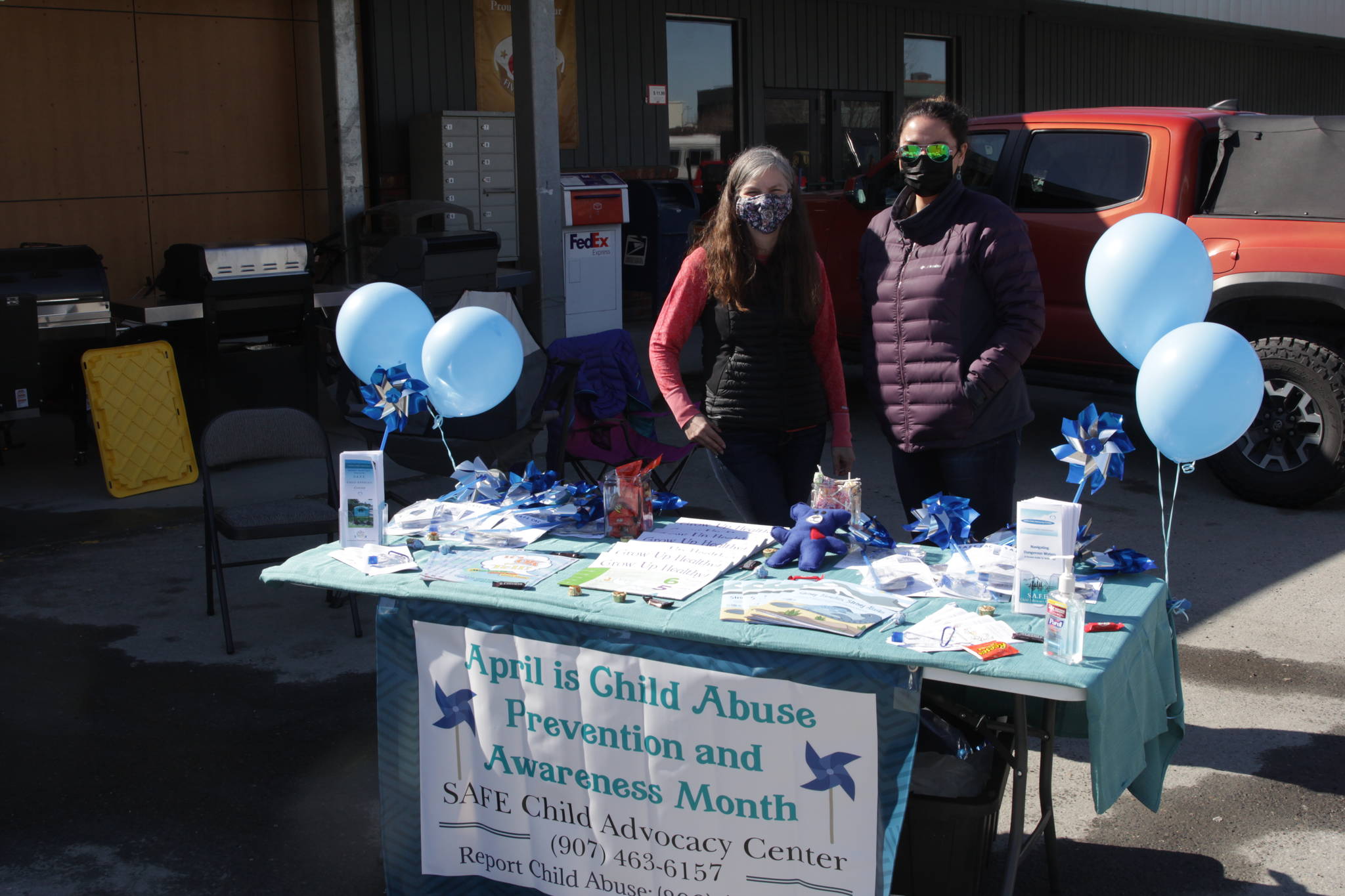Michael S. Lockett / Juneau Empire 
Susan Moseby, left, SAFE program administrator, and Jenny Farley, a nurse with the child advocacy center, man a table at IGA Foodland for Child Abuse Prevention Awareness month, giving information and resources to those who ask on April 16, 2021.