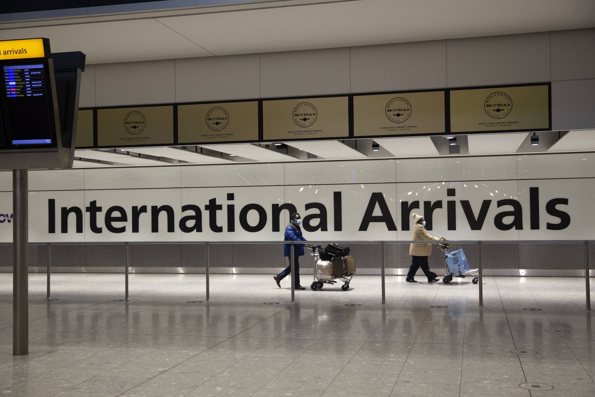 Arriving passengers walk past a sign in the arrivals area at Heathrow Airport in London, during England’s third national lockdown since the coronavirus outbreak began. On Tuesday, City and Borough of Juneau officials said the city has confirmed the first local case of a COVID-19 variant first detected in Britain. (AP Photo/Matt Dunham)