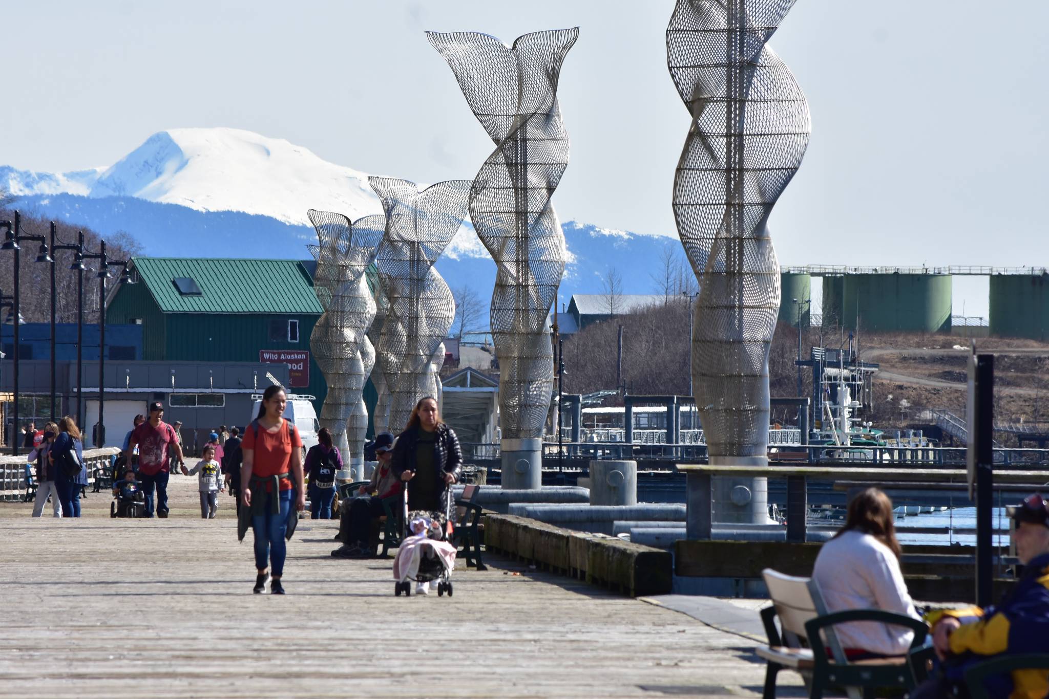 Juneauites enjoyed the sun on the downtown waterfront on Friday, April 16, 2021, but the city would normally be gearing up for cruise season. Gov. Mike Dunleavy released a proposal Friday for using more the $1 billion in federal relief money meant to boost local economies and update local infrastructure. (Peter Segall / Juneau Empire)