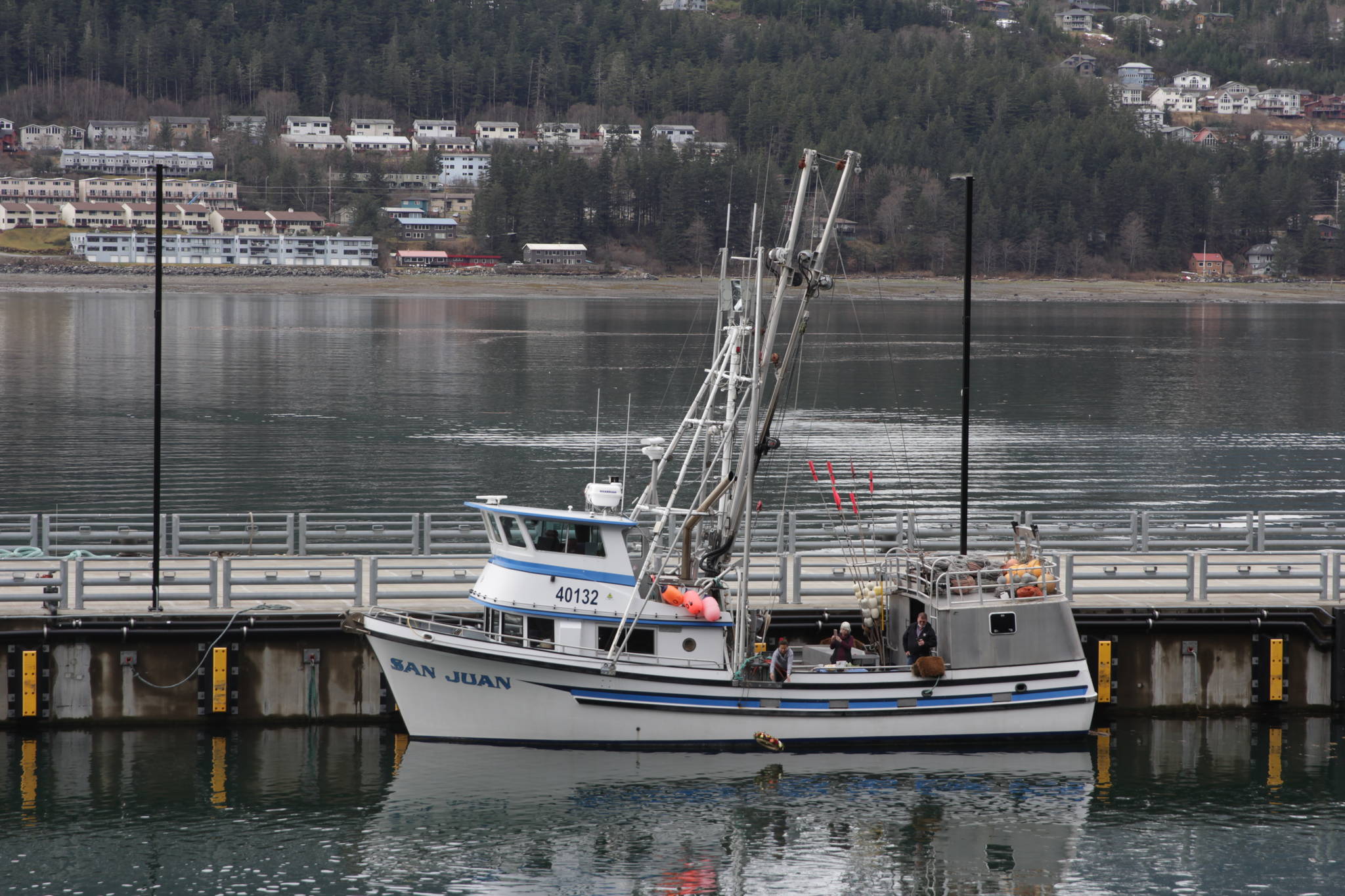 The crew of the fishing vessel San Juan release a memorial wreath into the Gastineau Channel during the 31st annual Blessing of the Fleet and Reading of Names at the Alaska Commercial Fishermen’s Memorial in Juneau on May 1, 2021. (Michael S. Lockett / Juneau Empire)
