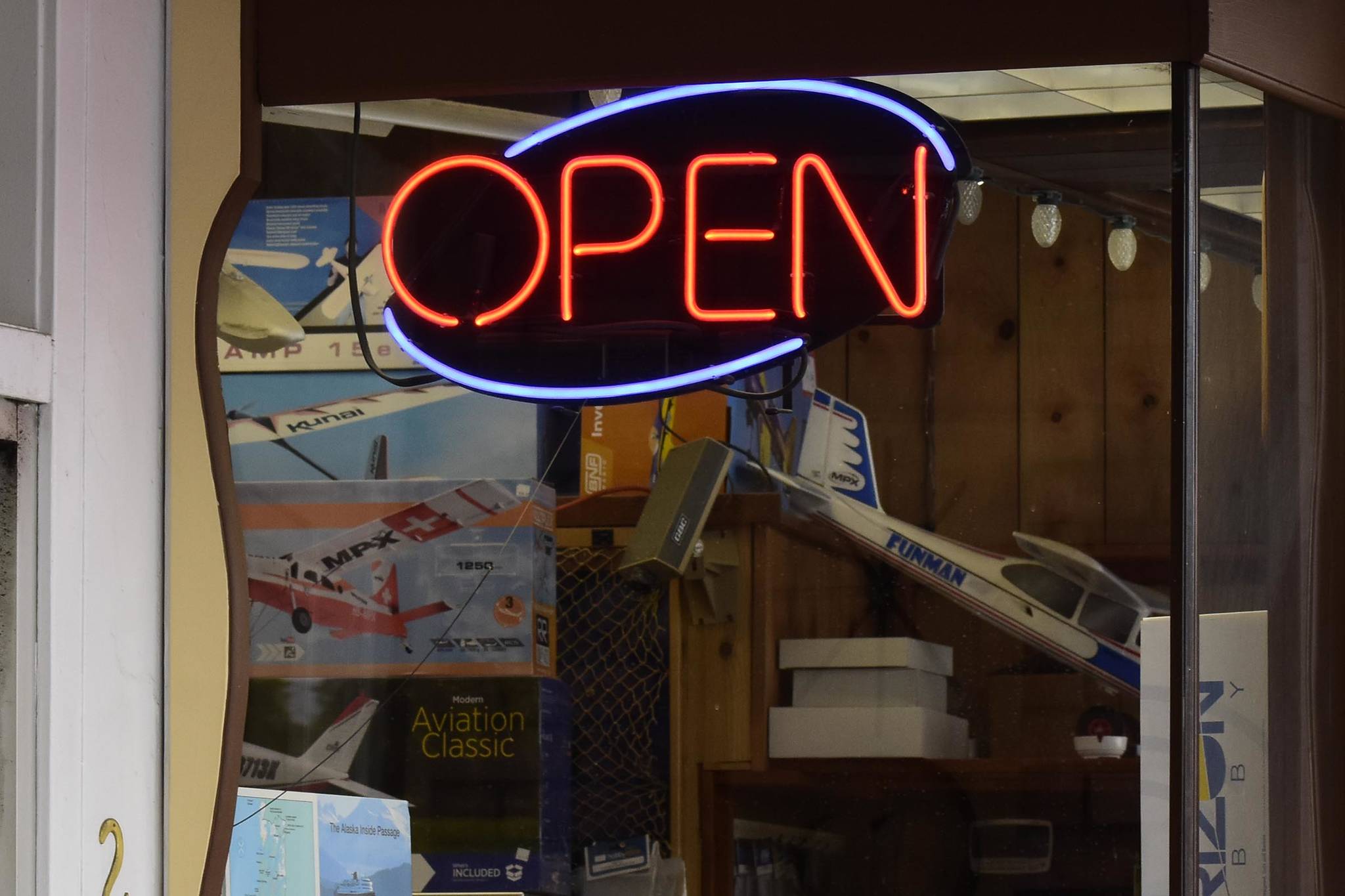 This May 2020 photo shows an open sign illuminated on a Juneau business. Alaska Department of Labor and Workforce  Development Commissioner Tamika L. Ledbetter announced on Friday the state will stop participating next month in a federal program that provides an extra $300 a week in unemployment aid. (Peter Segall / Juneau Empire File)