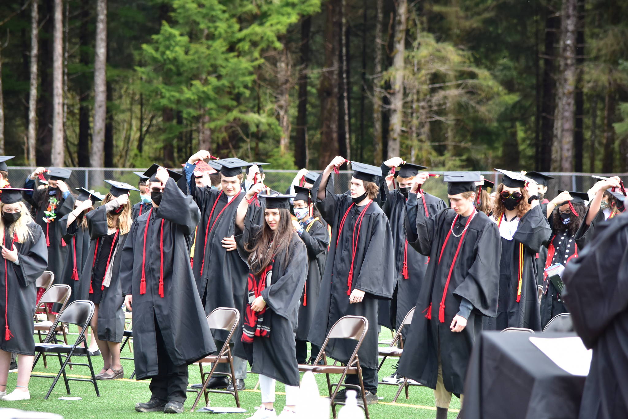 Below right, Juneau-Douglas High School:Yadaa.at Kalé Class of 2021 students move their tassels during the graduation ceremony on Sunday. 
Peter Segall / Juneau Empire