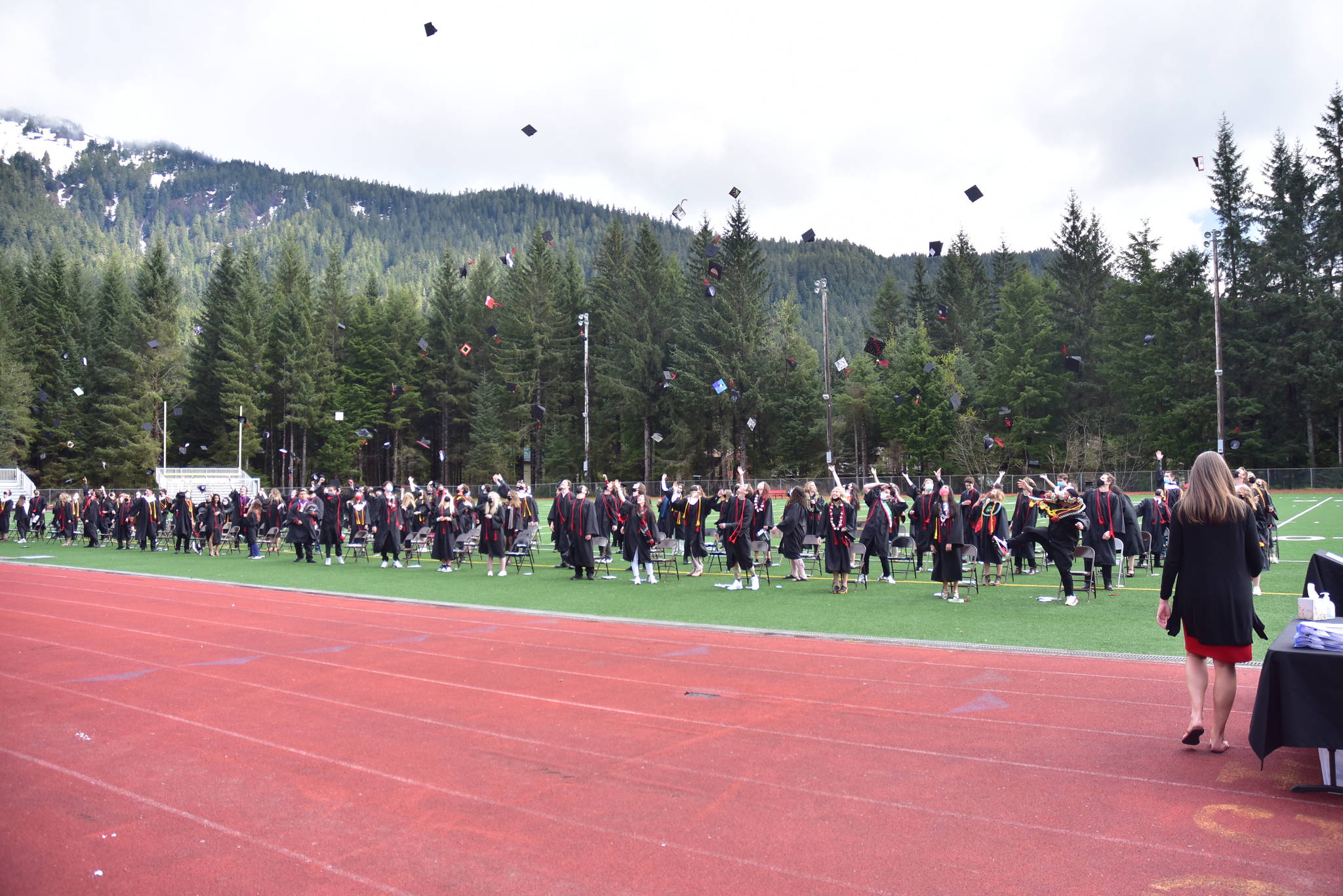 Juneau-Douglas High School:Yadaa.at Kalé Class of 2021 students throw their caps in celebration during the graduation ceremony at Adair Kennedy Memorial Park on Sunday, May 23, 2021. (Peter Segall / Juneau Empire)