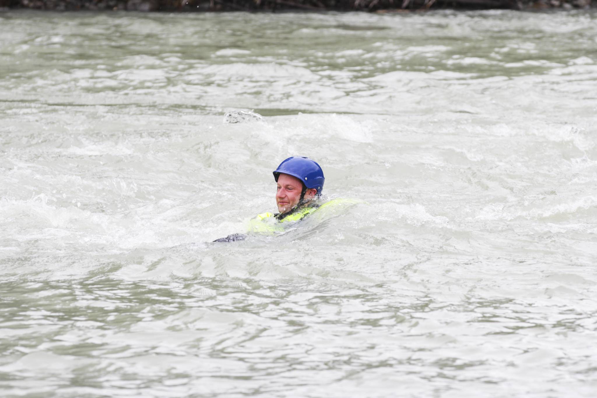 Chief Petty Officer Jeff Deronde floats downstream, simulating a victim in the water, as Capital City Fire/Rescue personnel and Coast Guardsmen practice swiftwater rescues in the Mendenhall River on as National Boating Safety Week wraps up on May 27, 2021. (Michael S. Lockett / Juneau Empire)