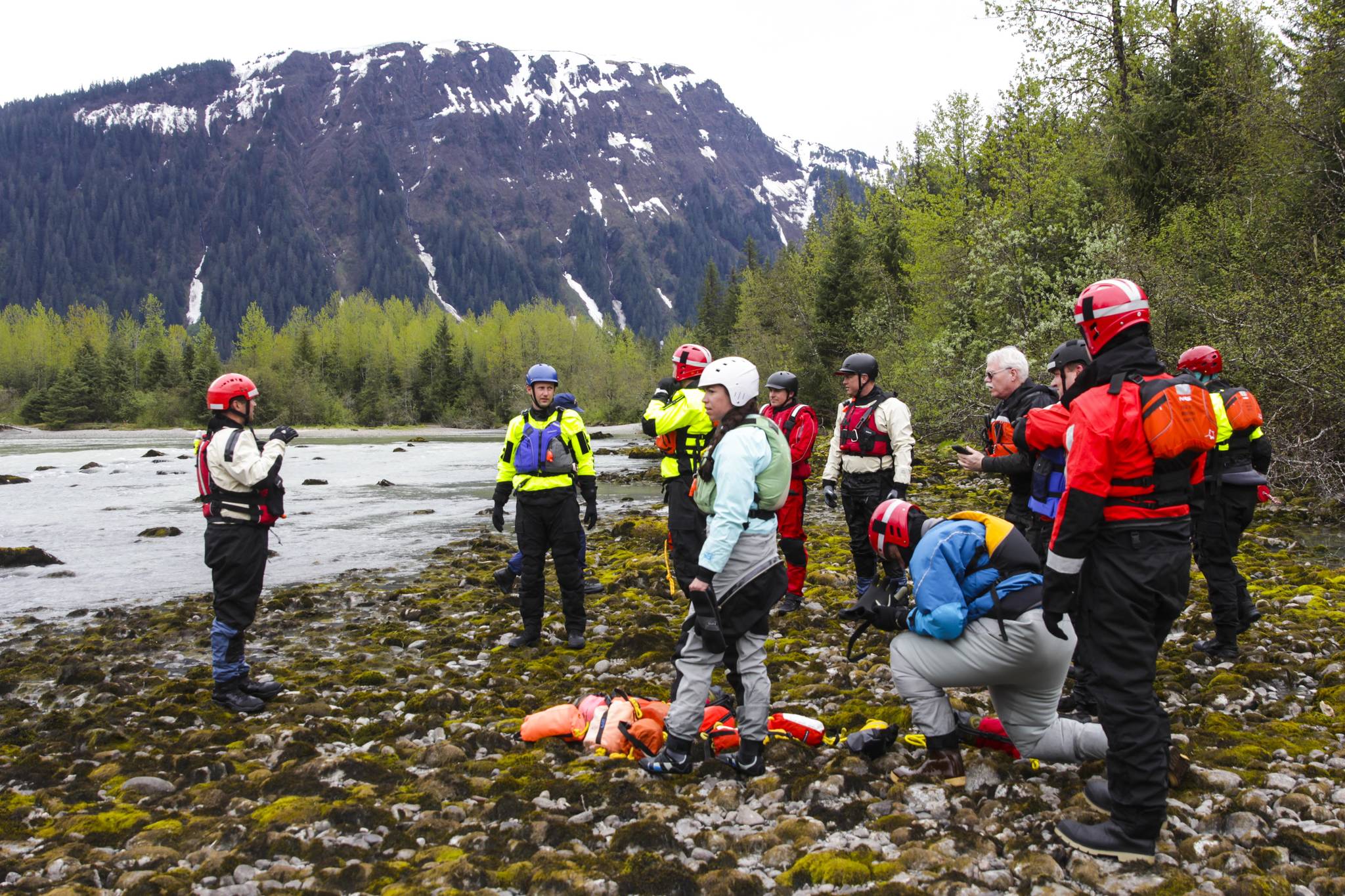 Capt. Jayme Johns, left, head of the Capital City Fire/Rescue’s water rescue team, briefs a group of CCFR personnel and Coast Guardsmen as they prepare to practice swiftwater rescues in the Mendenhall River on as National Boating Safety Week wraps up May 27, 2021. (Michael S. Lockett / Juneau Empire)