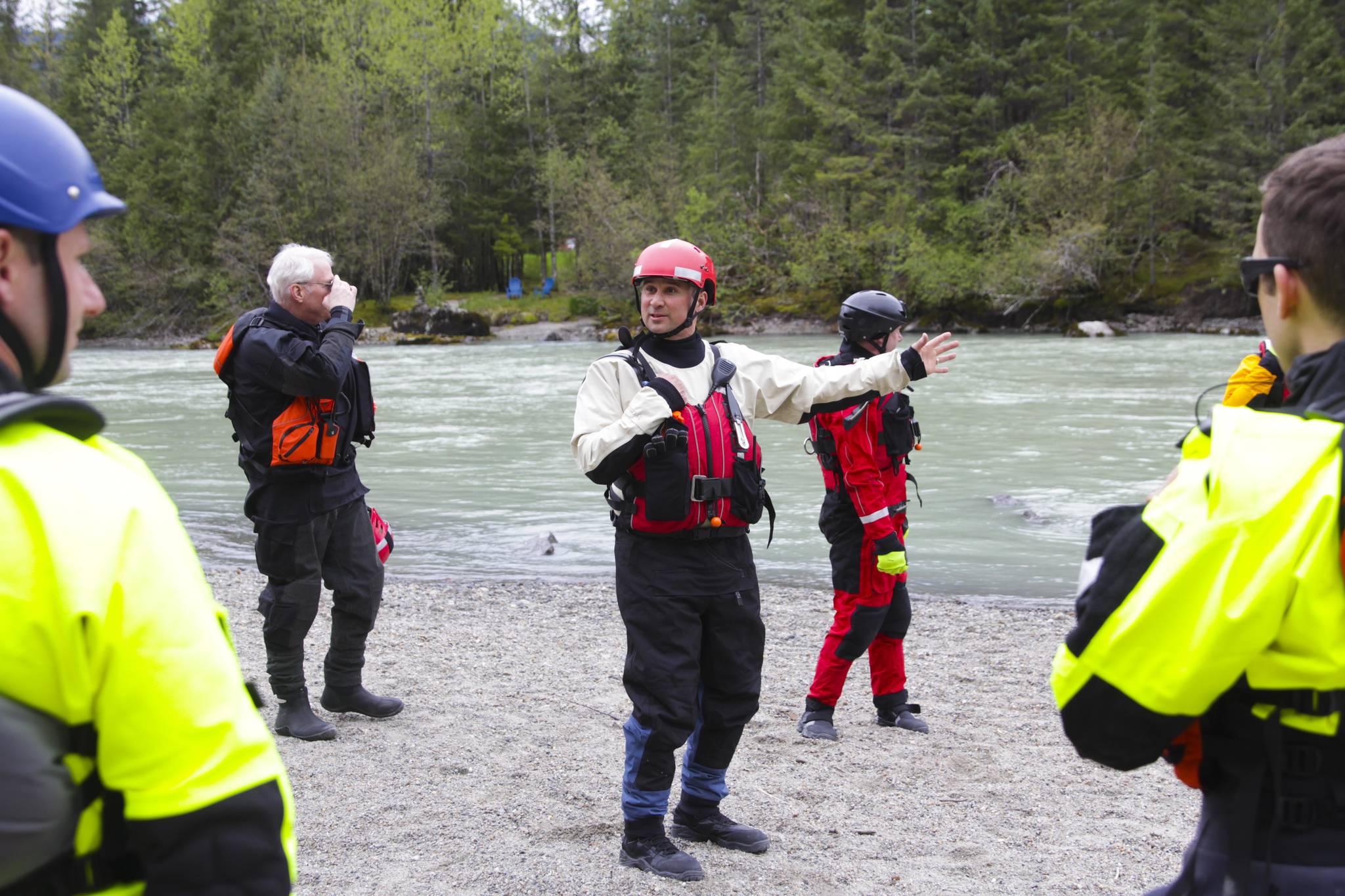 Capt. Jayme Johns, center, head of the Capital City Fire/Rescue’s water rescue team, briefs a group of CCFR personnel and Coast Guardsmen as they prepare to practice swiftwater rescues in the Mendenhall River on as National Boating Safety Week wraps up May 27, 2021. (Michael S. Lockett / Juneau Empire)