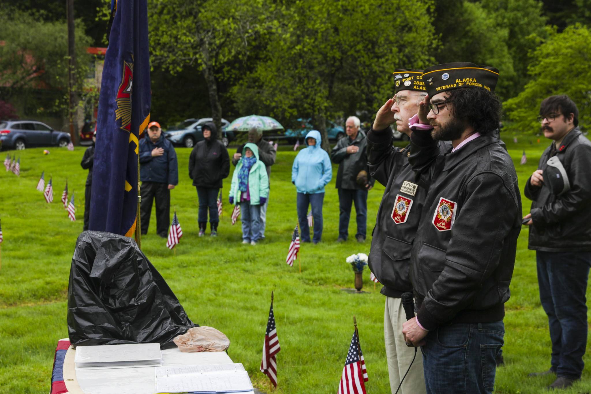 Veterans of Foreign Wars Post 5559 junior vice commander David Carroll, nearer, and post service officer Tom Armstrong, further, salute during a Memorial Day ceremony at Evergreen Cemetery on May 31, 2021. (Michael S. Lockett / Juneau Empire)