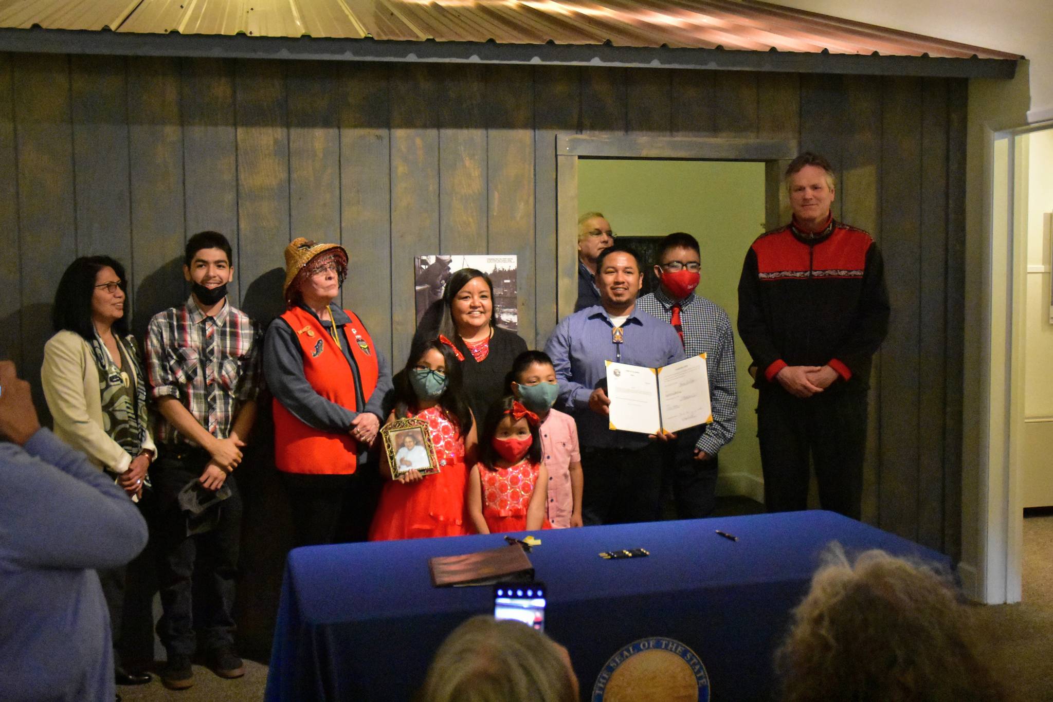 Martin Stepetin Sr. holds up a signed bill protecting a cemetery in Funter Bay at a ceremony with Gov. Mike Dunleavy and several lawmakers and community members at the Juneau-Douglas City Museum on Tuesday, June 8, 2021. (Peter Segall / Juneau Empire)
