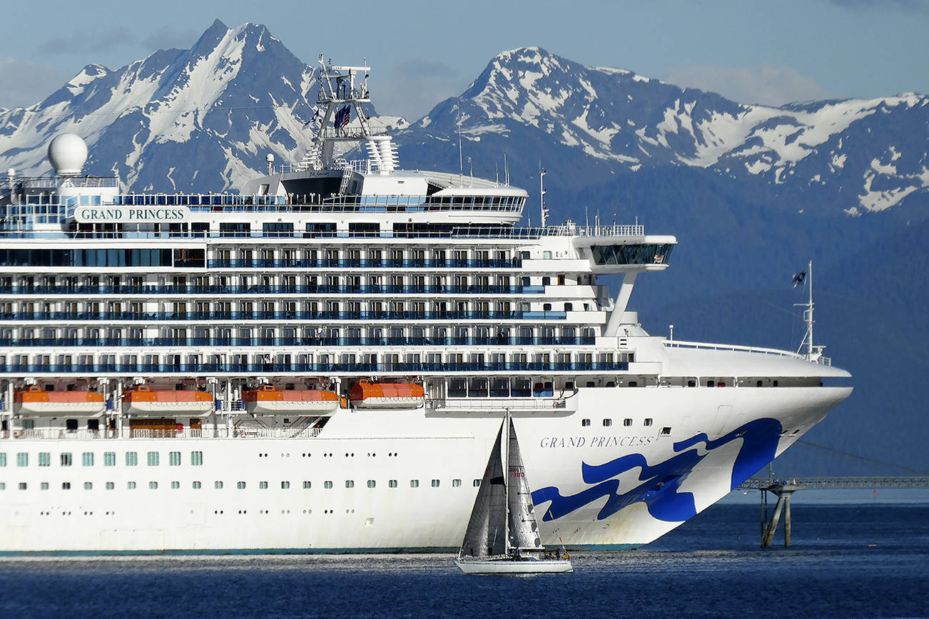 In this photo taken Wednesday, May 30, 2018, a sail boat maneuvers near a large cruise ship near Juneau, Alaska. On Monday night, members of the City and Borough of Juneau’s Committee of the Whole considered whether to authorize city manager Rorie Watt to enter into port agreements that allow unvaccinated minors to visit Juneau with their families as long as certain conditions are met. (AP Photo/Becky Bohrer, file)
