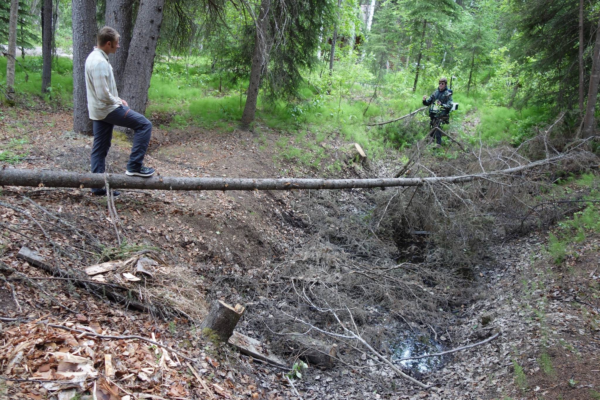 ason Clark, at left, a postdoctoral researcher at UAF, and Nicholas Hasson, a UAF graduate student, examine a sinkhole known as a thermokarst in a Fairbanks homeowner’s backyard. (Courtesy Photo / Ned Rozell)