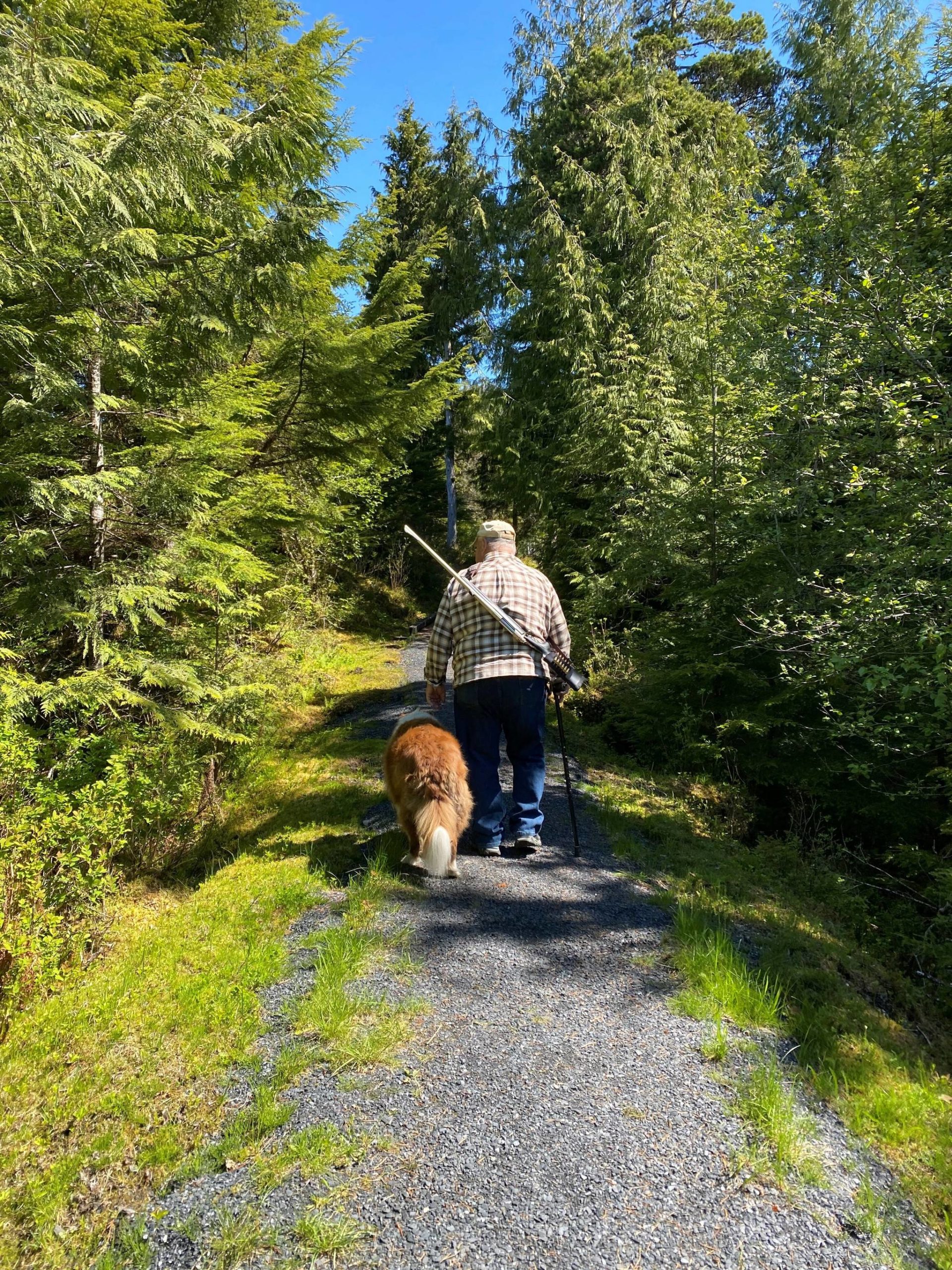 Mitchell “Mickey” Prescott and Oscar walk down a forest path in Wrangell. (Vivian Faith Prescott / For the Capital City Weekly)