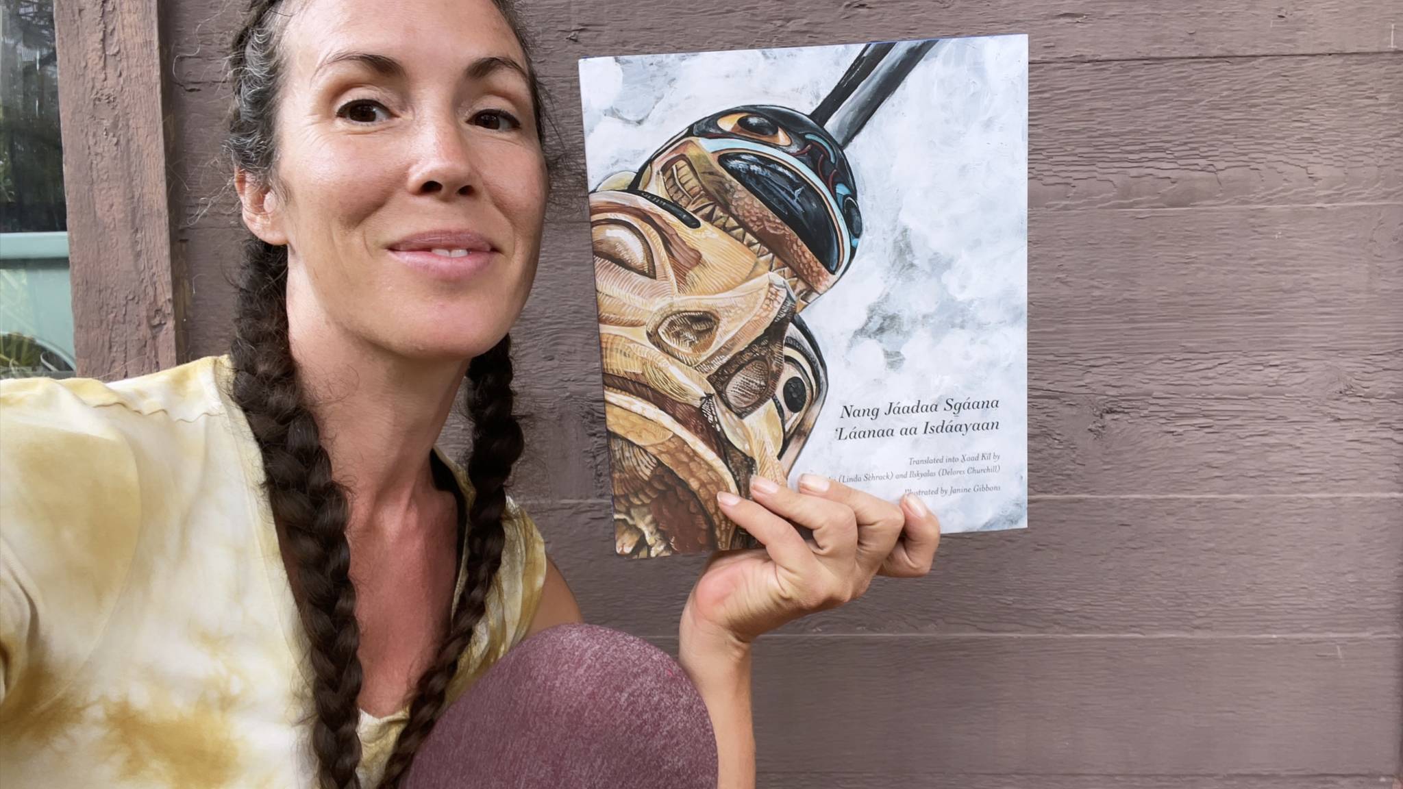 Courtesy photo / Janine Gibbons
Haida artist Janine Gibbons poses with the book she illustrated, the Sealaska Heritage Institute’s first children’s book in the Haida language Xaad Kíl, a translation of the traditional story “The Woman Carried Away by Killer Whales.”