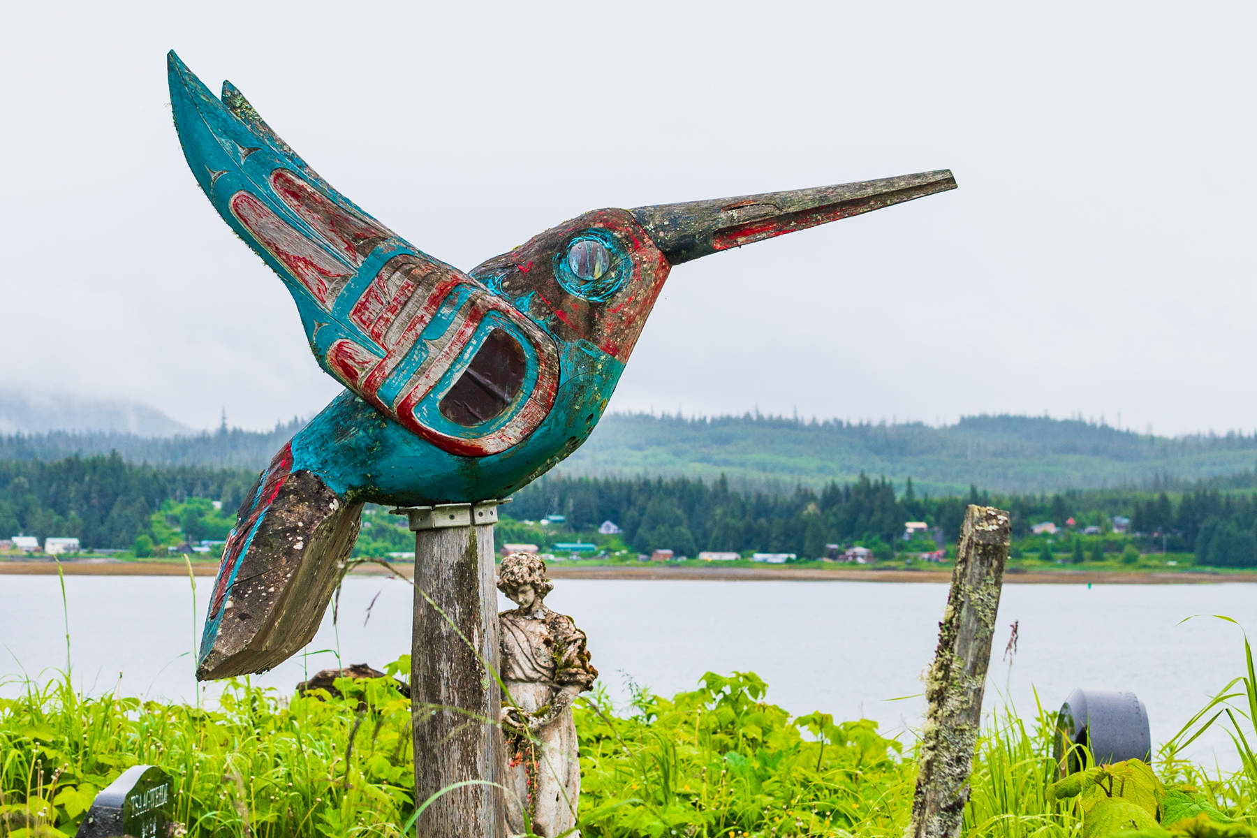 A hummingbird carving marks a site on Grave Island against the backdrop of the Tlingit community of Kake. (Courtesy Photo / Lione Clare)