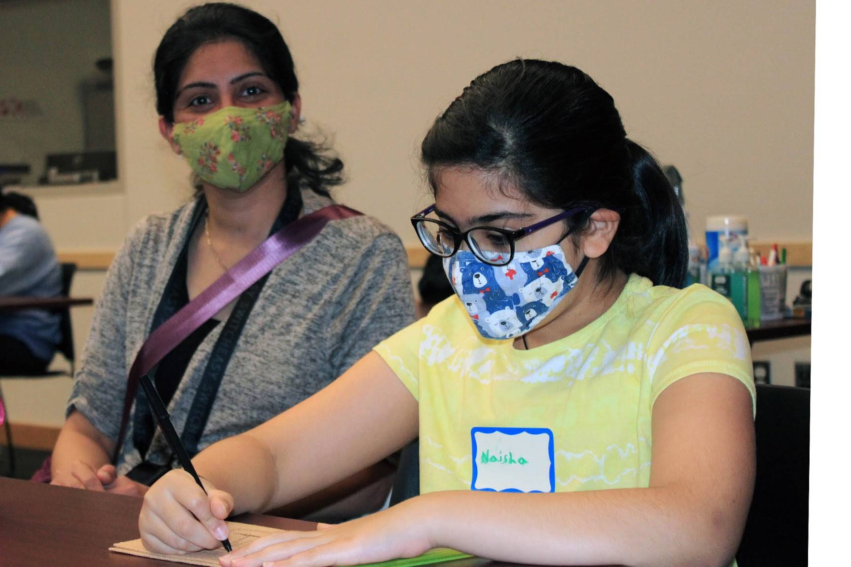 Naisha Bathija, 9, and her mother Neelam work on a Ravenstail pattern beading project at the Alaska State Library, Archives and Museum on June 26, 2021. (Dana Zigmund/Juneau Empire)