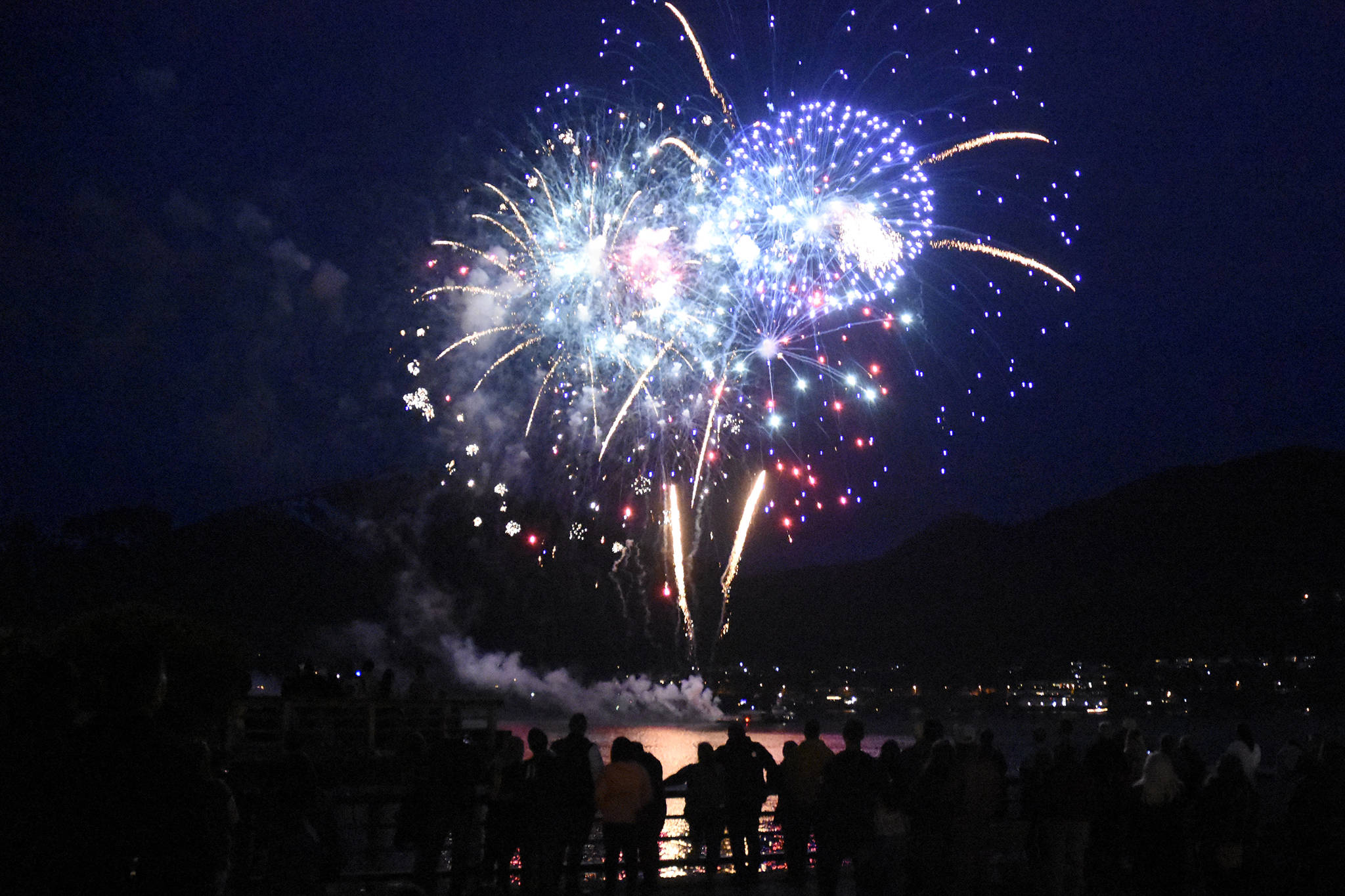 Fireworks light up the night sky over the Gastineau Channel with reds, whites and blues in the early hours of the Fourth of July. Personal fireworks were being shot off nearby, leading one onlooker to shout, “Double fireworks! I love America!” (Peter Segall / Juneau Empire)