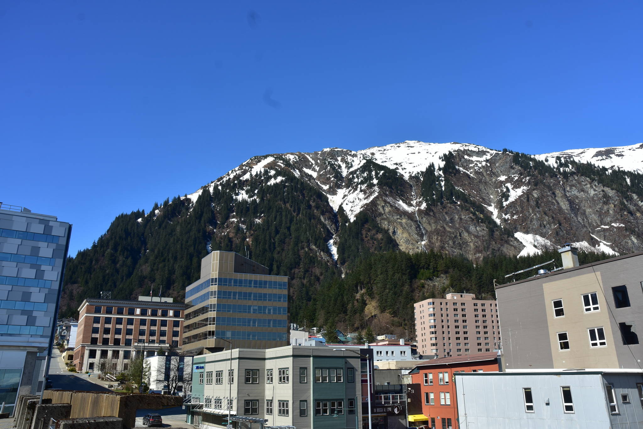 Mount Juneau, looms above downtown Juneau in this April 2021 photo. More structures and swaths of  land in downtown Juneau are located in avalanche or landslide-prone areas, according to new maps commissioned by the City and Borough of Juneau. (Peter Segall / Juneau Empire File)