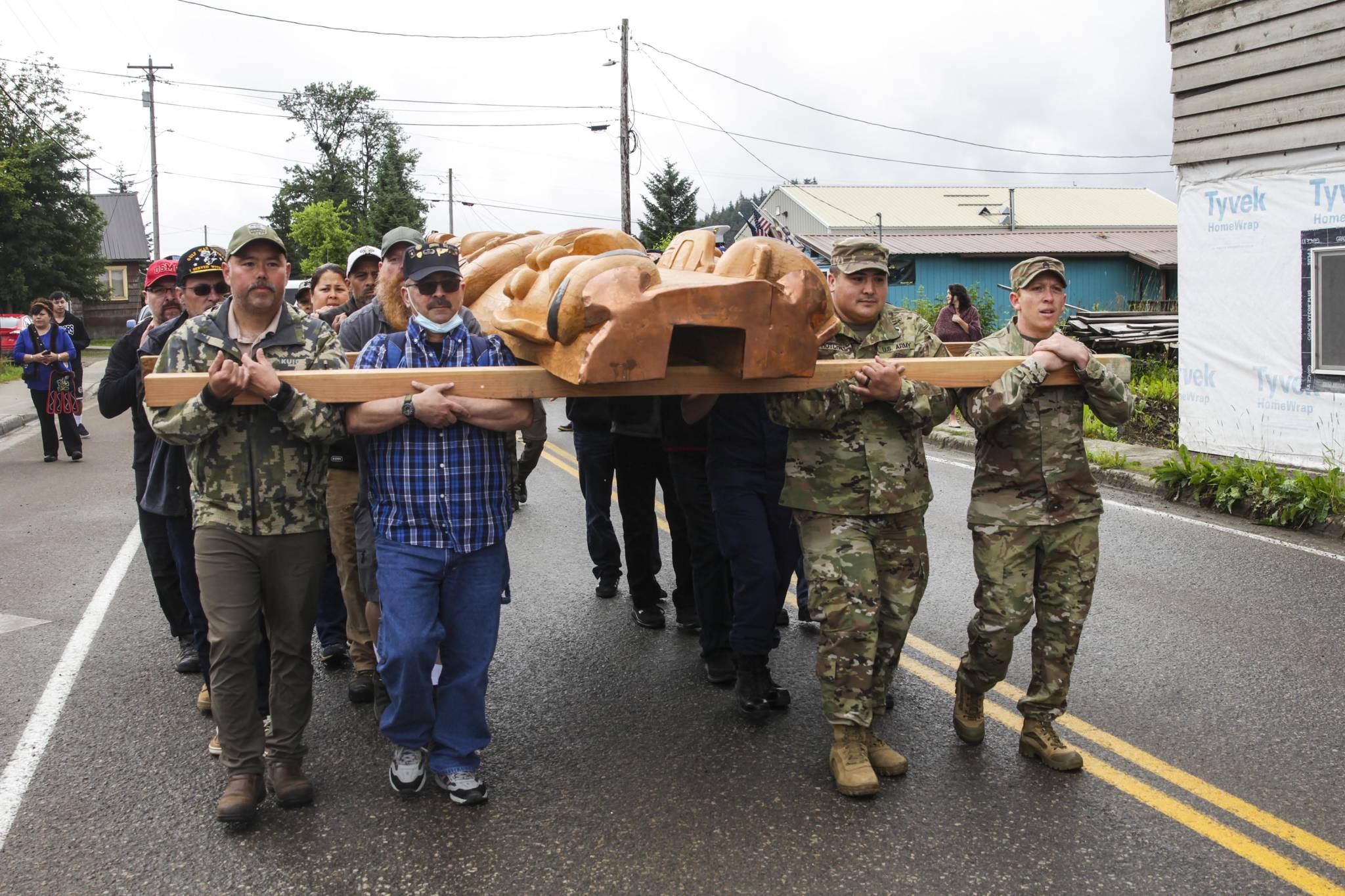 Veterans and active duty servicemembers carry the totem pole on July 24, 2021 as hundreds gathered in Hoonah for its raising. (Michael S. Lockett / Juneau Empire)