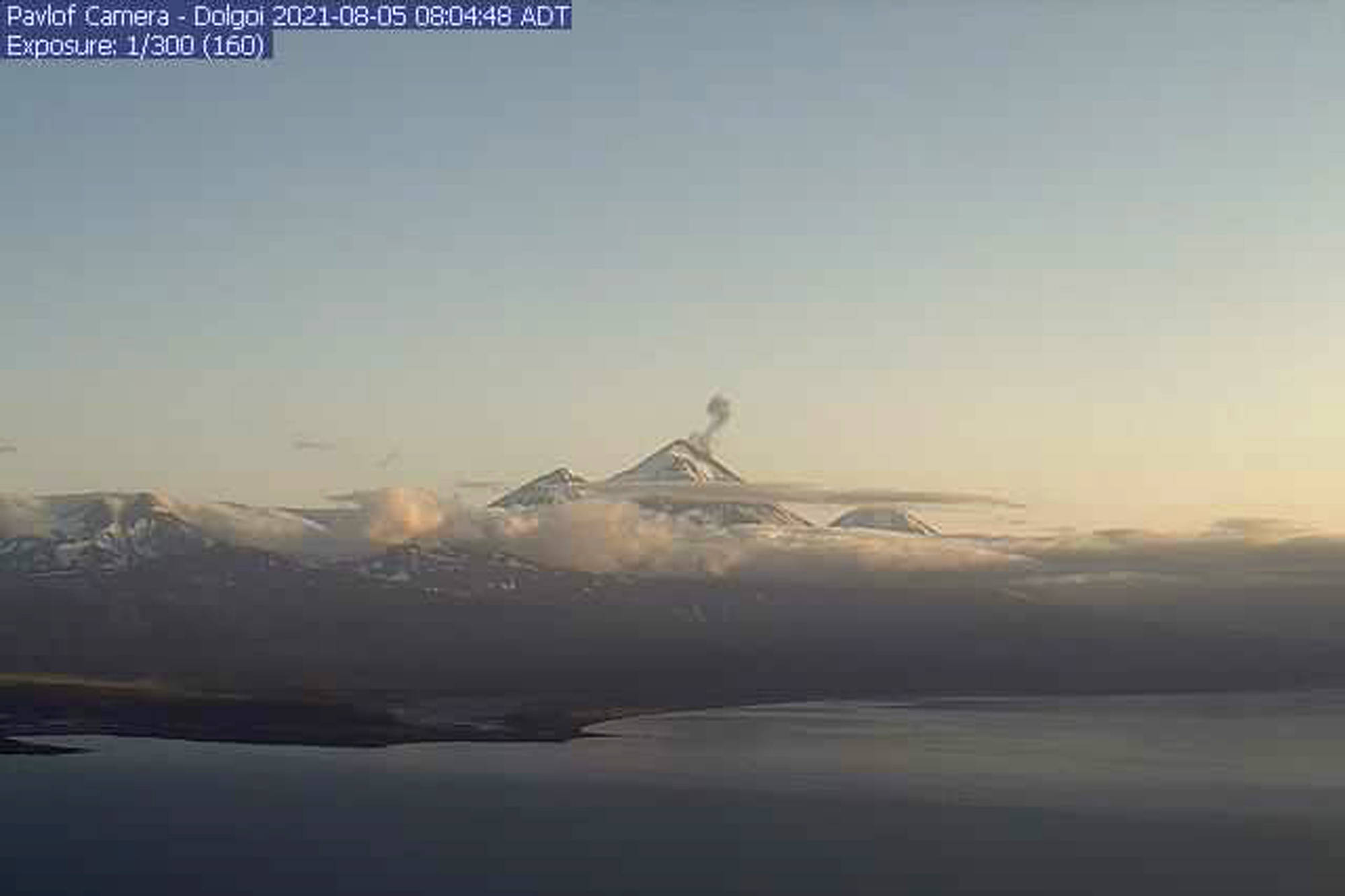 In this webcam image is the Pavlof Volcano in a state of eruption with episodic low-level ash emissions on Thursday, Aug. 5, 2021. Three remote Alaska volcanos are each in a state of eruption, one producing lava and the other two blowing steam and ash. So far, no small communities near any of the three have been impacted, Chris Waythomas, a geologist with the Alaska Volcano Observatory, said Thursday. (Alaska Volcano Observatory)