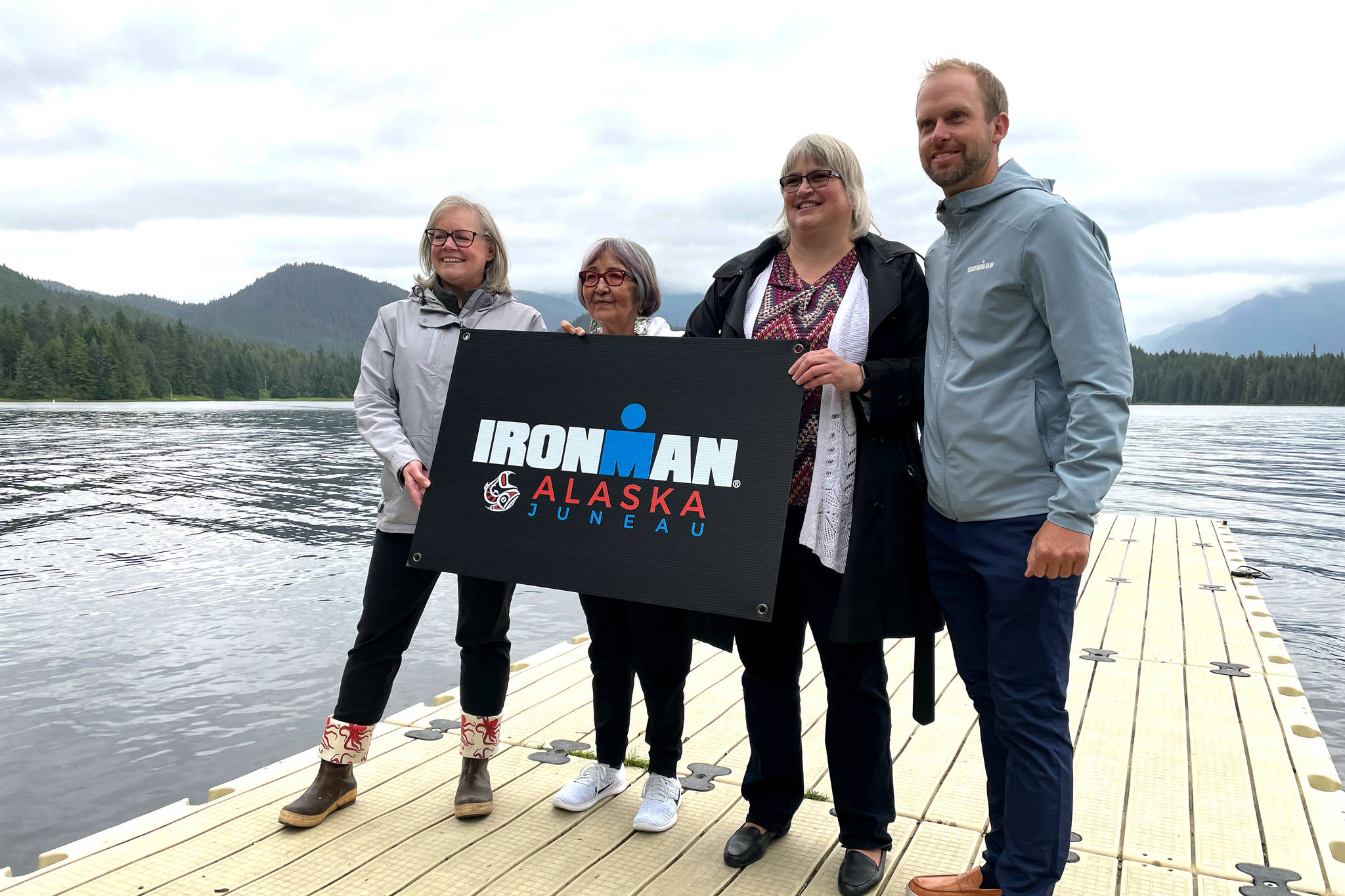 Travel Juneau CEO and President Liz Perry, Sealaska Heritage Institute President Rosita Worl, City and Borough of Juneau Mayor Beth Weldon, and Ironman regional director Dave Christen hold a sign for the 2022 Juneau Ironman event as they announce the race’s Alaska debut on the University of Alaska- Southeast campus on Aug. 9, 2021. (Michael S. Lockett / Juneau Empire)