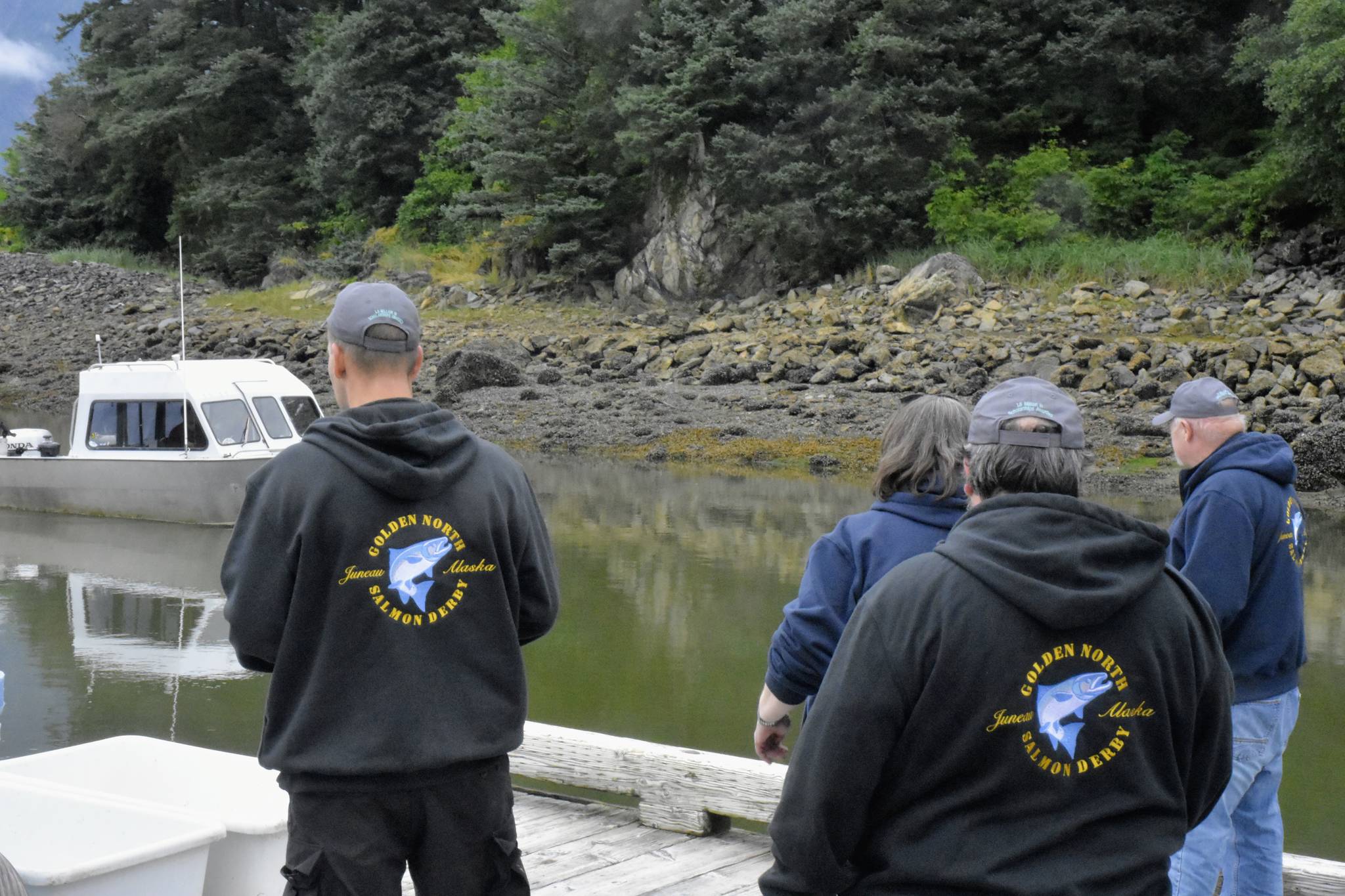 Dock volunteers prepare to greet a boat at the Mike Pusich Douglas Harbor weigh station for the 75th annual Golden North Salmon Derby on Saturday, Aug. 14, 2021. This boat turned out not to be involved in the derby, but the volunteers were ready nonetheless. (Peter Segall / Juneau Empire)