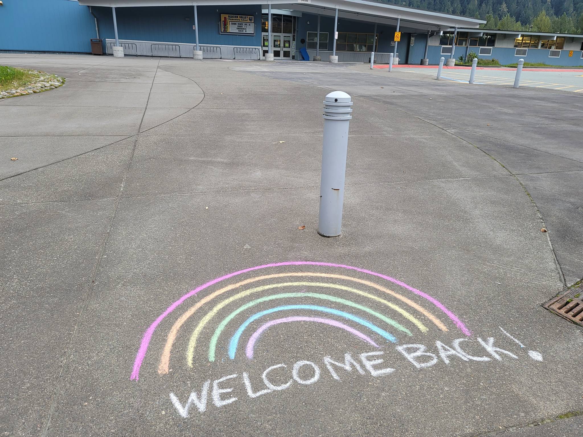A sidewalk-based message welcomes students and staff back to Glacier Valley Elementary School ahead of the first day of school on Monday, Aug. 16. (Ben Hohenstatt/Juneau Empire)