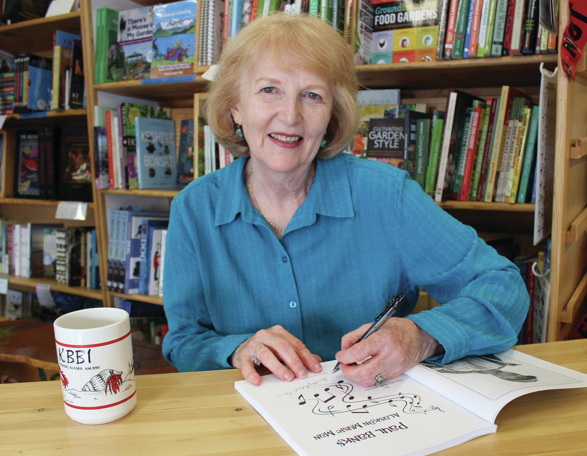 Author Dorothy “Dotty” Cline signs copies of “Paul Banks, Alaskan Music Man” at the Homer Bookstore on Sept. 27, 2014, in Homer, Alaska. (Photo by McKibben Jackinsky / Homer News File)