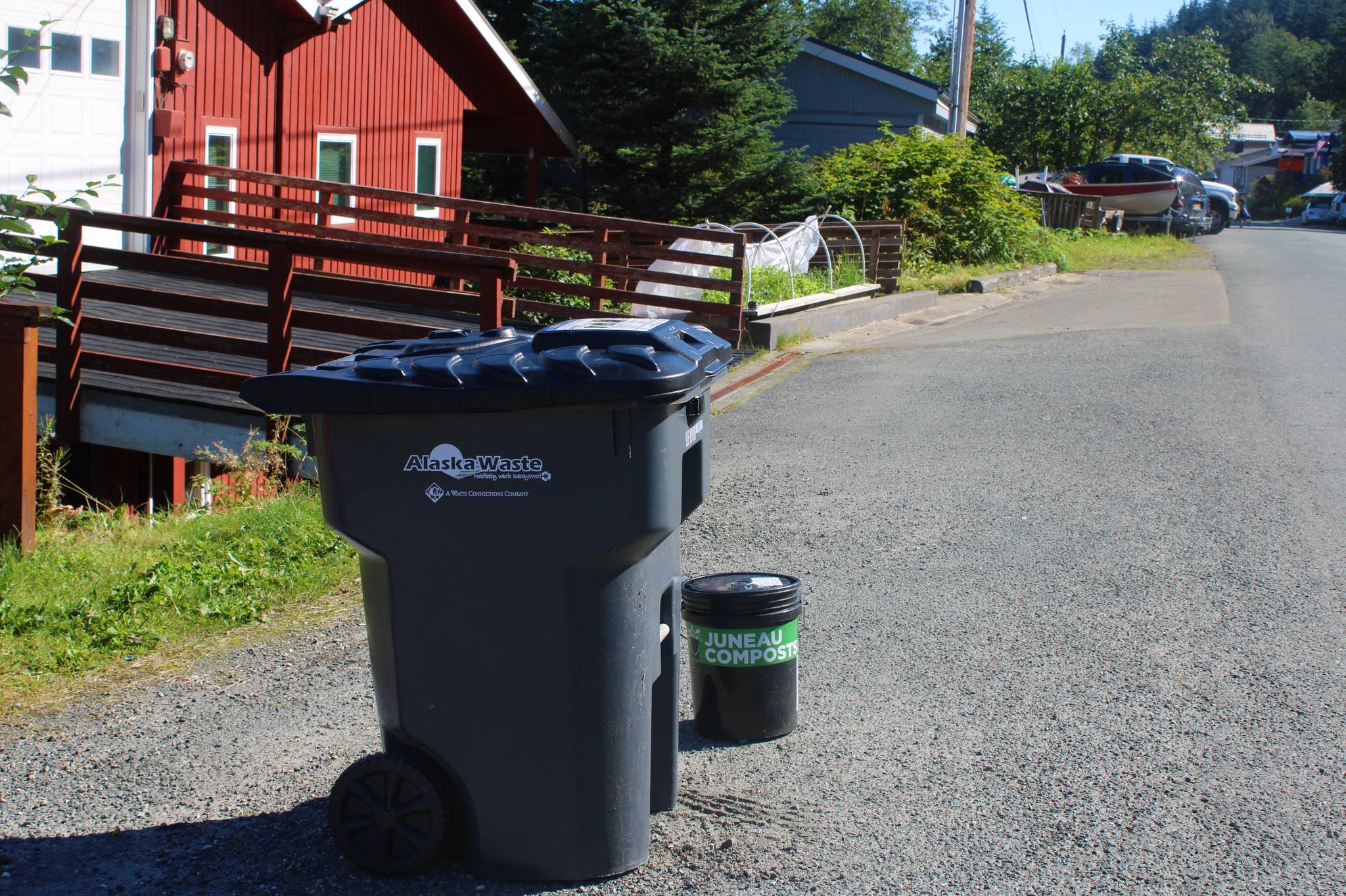 Dana Zigmund/Juneau Empire 
A garbage can sits next to a bin from Juneau Compost on Douglas on August 31. According to company officials, each day Juneau adds about 100 tons of garbage to the Capitol Disposal Landfill near Lemon Creek. At that rate, officials expect the landfill to be full in about 20 years. The city is exploring new ways to deal with Juneau’s waste stream, including composting options.
