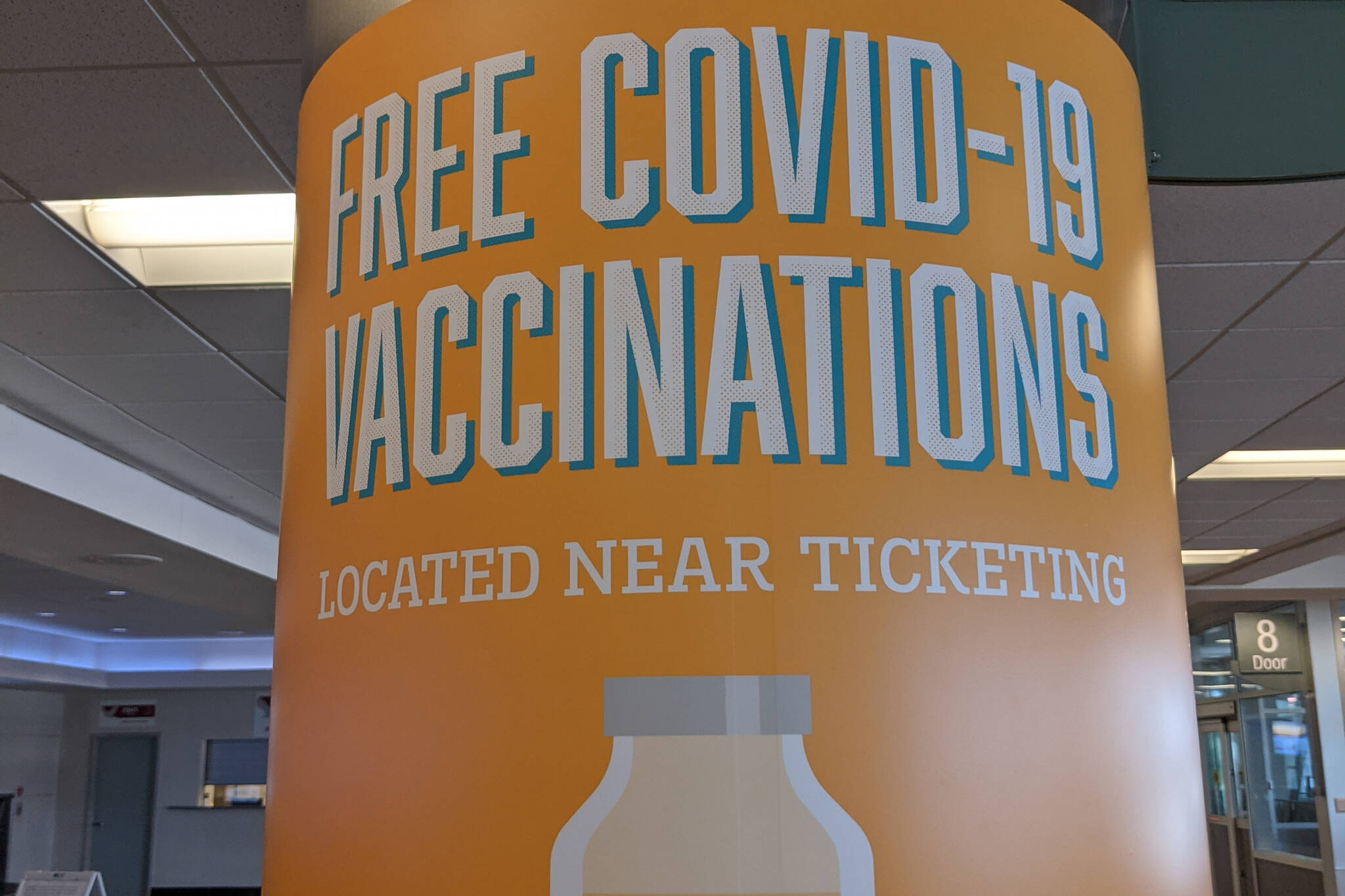 A sign advertises free COVID-19 vaccines at the Ted Stevens Anchorage International Airport on July 13, 2021, in Anchorage, Alaska. The state announced a new initiative that gives newly vaccinated Alaskans an opportunity to win $49,000. (Photo by Erin Thompson/Peninsula Clarion)